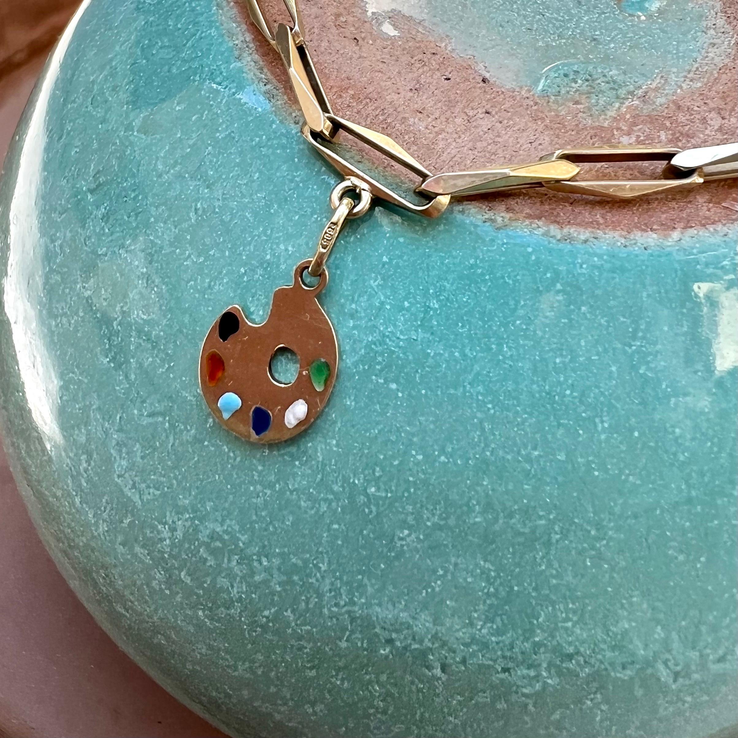 A preloved painters palette charm pendant smeared with different colors of paint on the palette. The charm is beautifully stylized and crafted in 14 karat gold. Charms are great to collect as wearable memories, it has a symbolic and often a