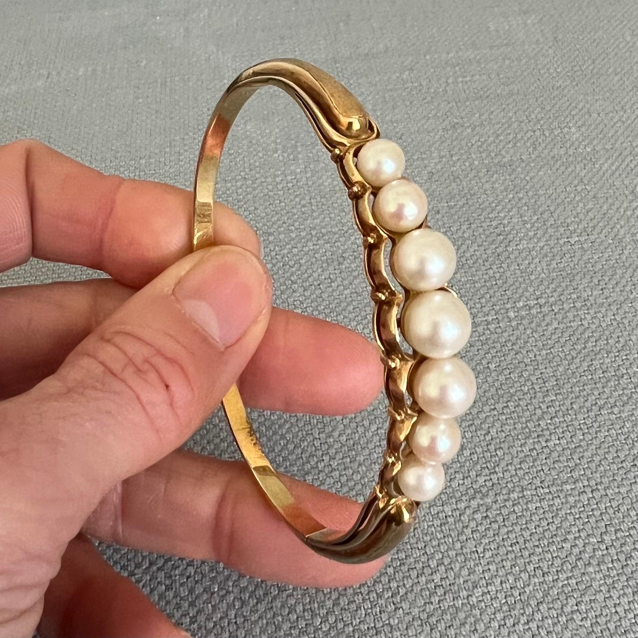 This vintage 14 karat gold pearl bangle bracelet is magnificent! The bracelet features one row of Akoya pearls on a gorgeous made 14 karat gold setting. The bangle is adorned with seven pearls with beautiful luster and shine. The upper part of the