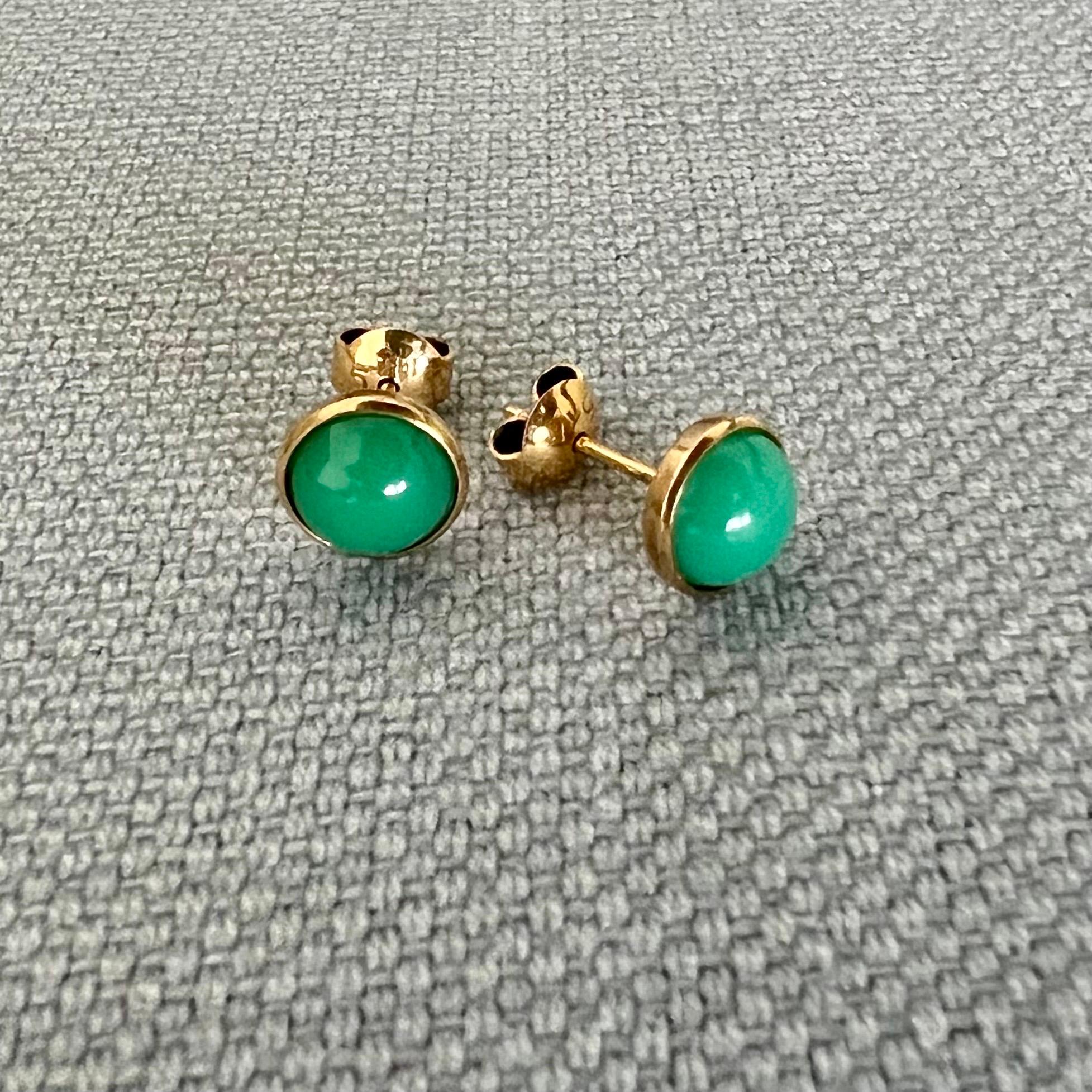 Une magnifique paire de délices verts -  ces boucles d'oreilles vintage en jade et or. Les clous en jade naturel sont sertis dans une monture en or 14 carats. Les clous sont ornés d'une pierre ronde cabochon en jade vert. Les pierres de jade ont une