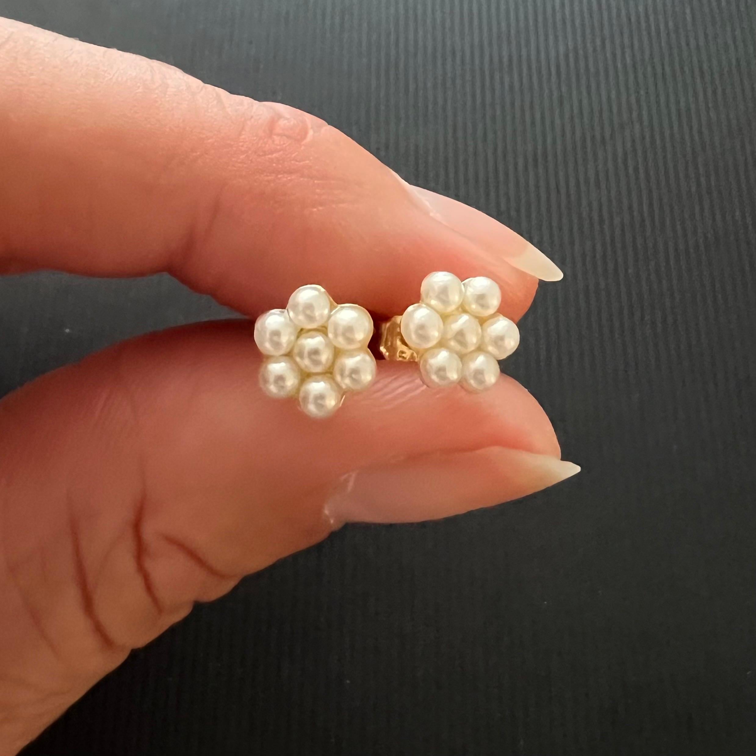 These lovely mid-century vintage cultured pearl stud earrings are created in 9 karat yellow gold. The earrings are embellished with seven round-shaped cultured pearls. Pearls are the gems of the sea and add femininity, refinement, and sophistication