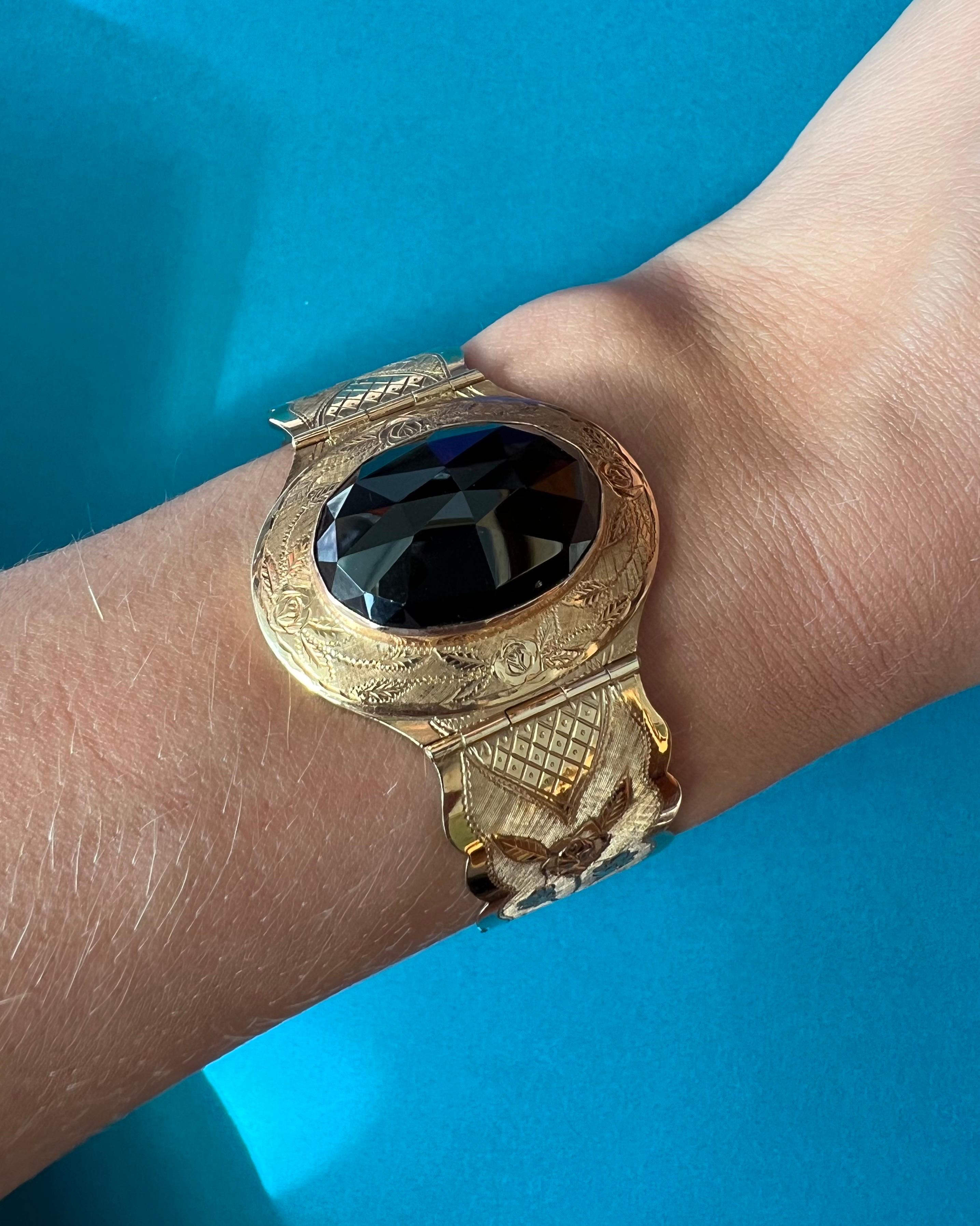A beautiful bracelet from the Late Victorian era, circa 1870s-1890s. Made from 14 karat rose gold, the design has a gorgeous combination with the deeply colored rose cut Almandine garnet and the engraved gold. The band of the bracelet is hinged with