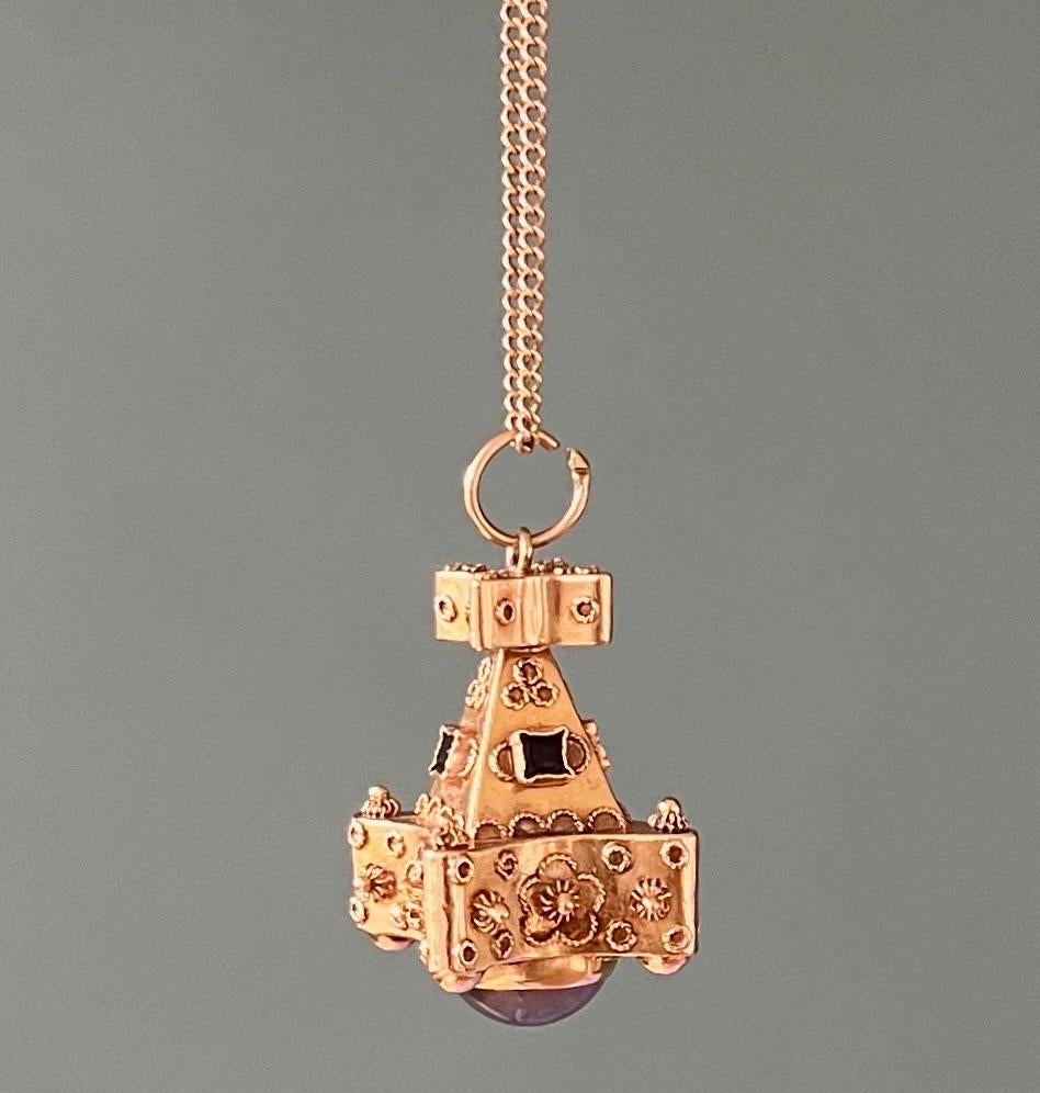 A beautiful preloved 18 karat gold Venetian Etruscan Revival fob charm pendant. The charm is set with a cabochon cut moonstone at the bottom of the pendant. The gold surface is decorated with cannetille, rope motifs, rosettes and wirework. The