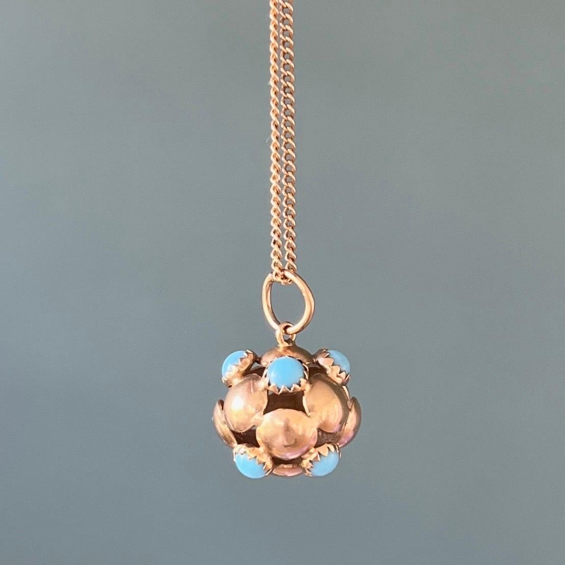 A vintage 18 karat yellow gold and turquoise ball charm pendant. The charm is marvelous and beautifully crafted with turquoise cabochon stones around the body. The gold of the ball is interspersed with an openwork structure between each gold