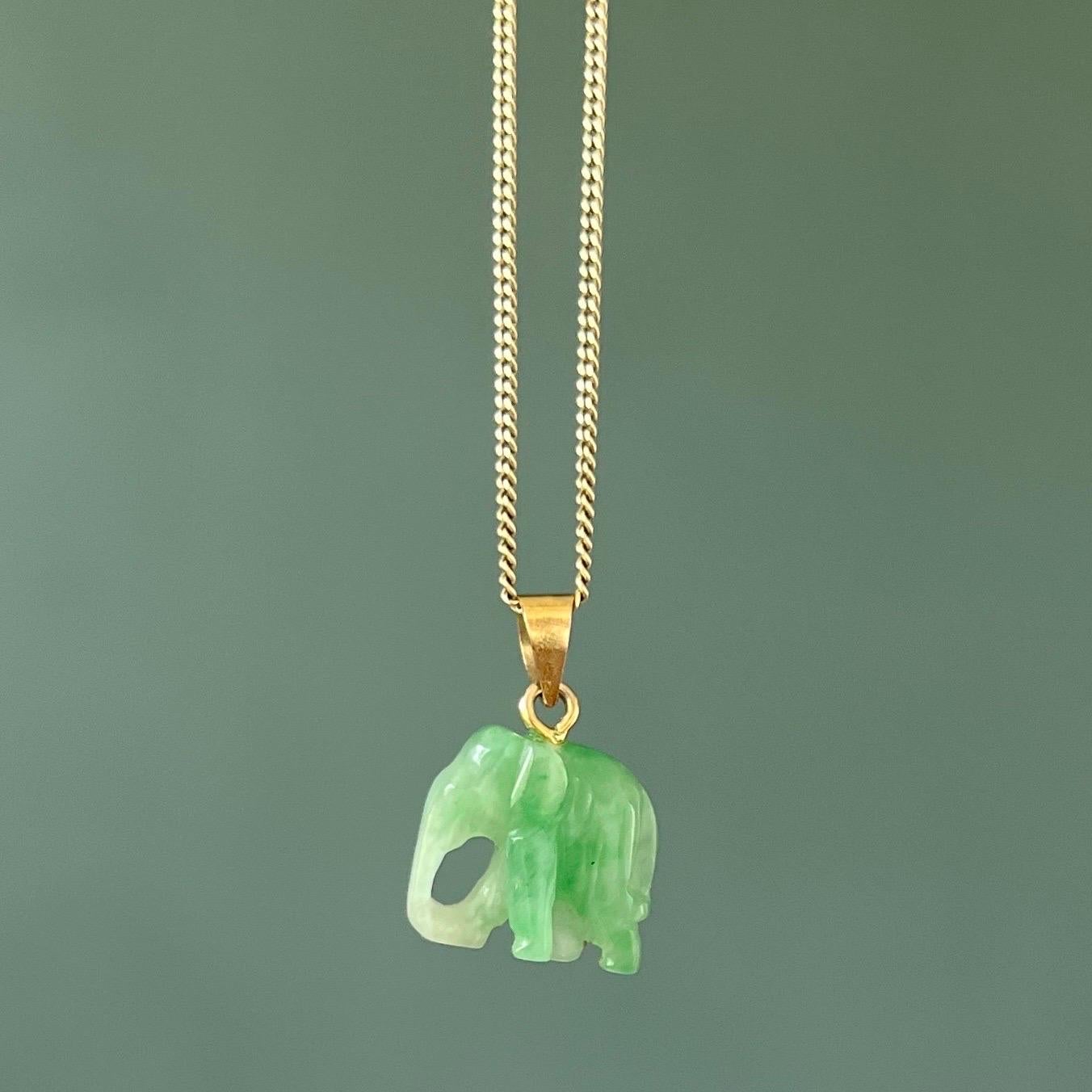 A gorgeous jade pendant carved into a sweet little elephant. This natural translucent green jade is set with a 14 karat gold bail. The jade is carved into this lovely elephant which has a walking posture. Elephants are symbols of luck and