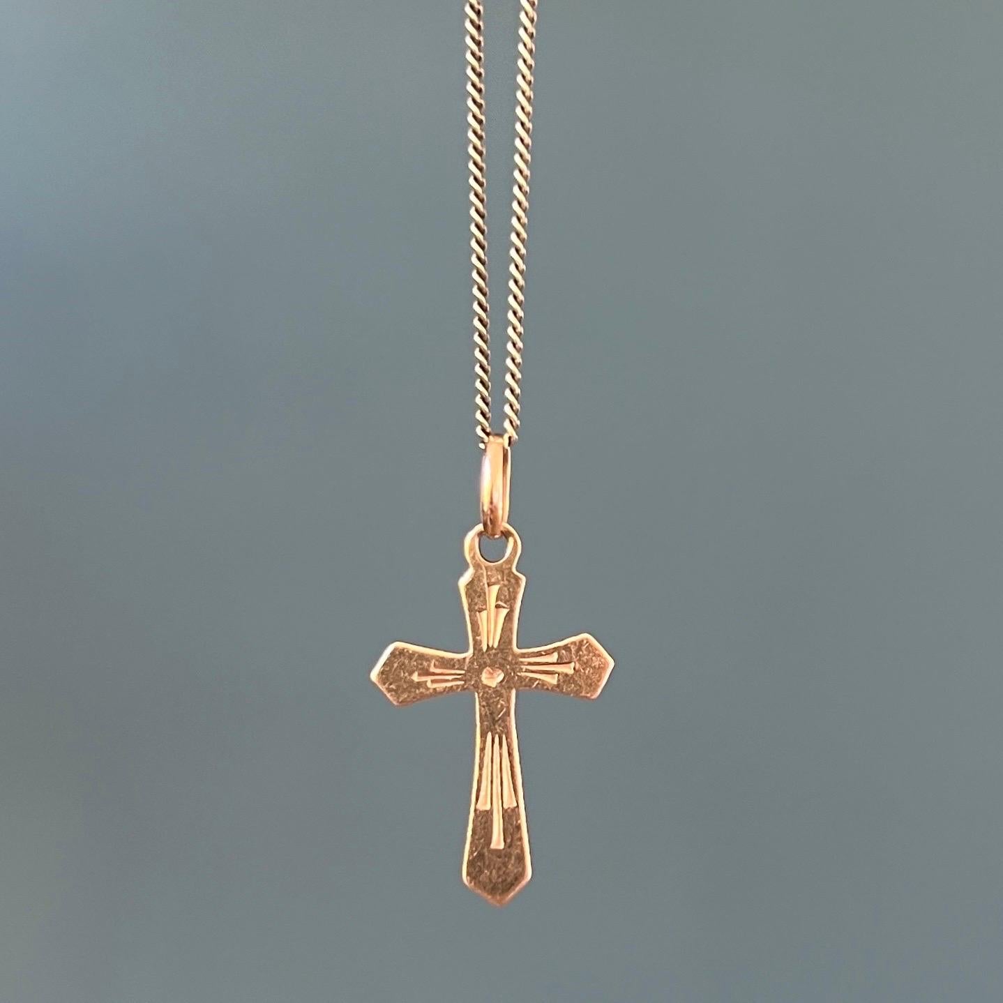 An Italian 18 karat gold cross charm pendant. This vintage religious cross charm has a beautiful design with engraved details. Charms are great to collect as wearable memories, it has a symbolic and often a sentimental value. They can be added to