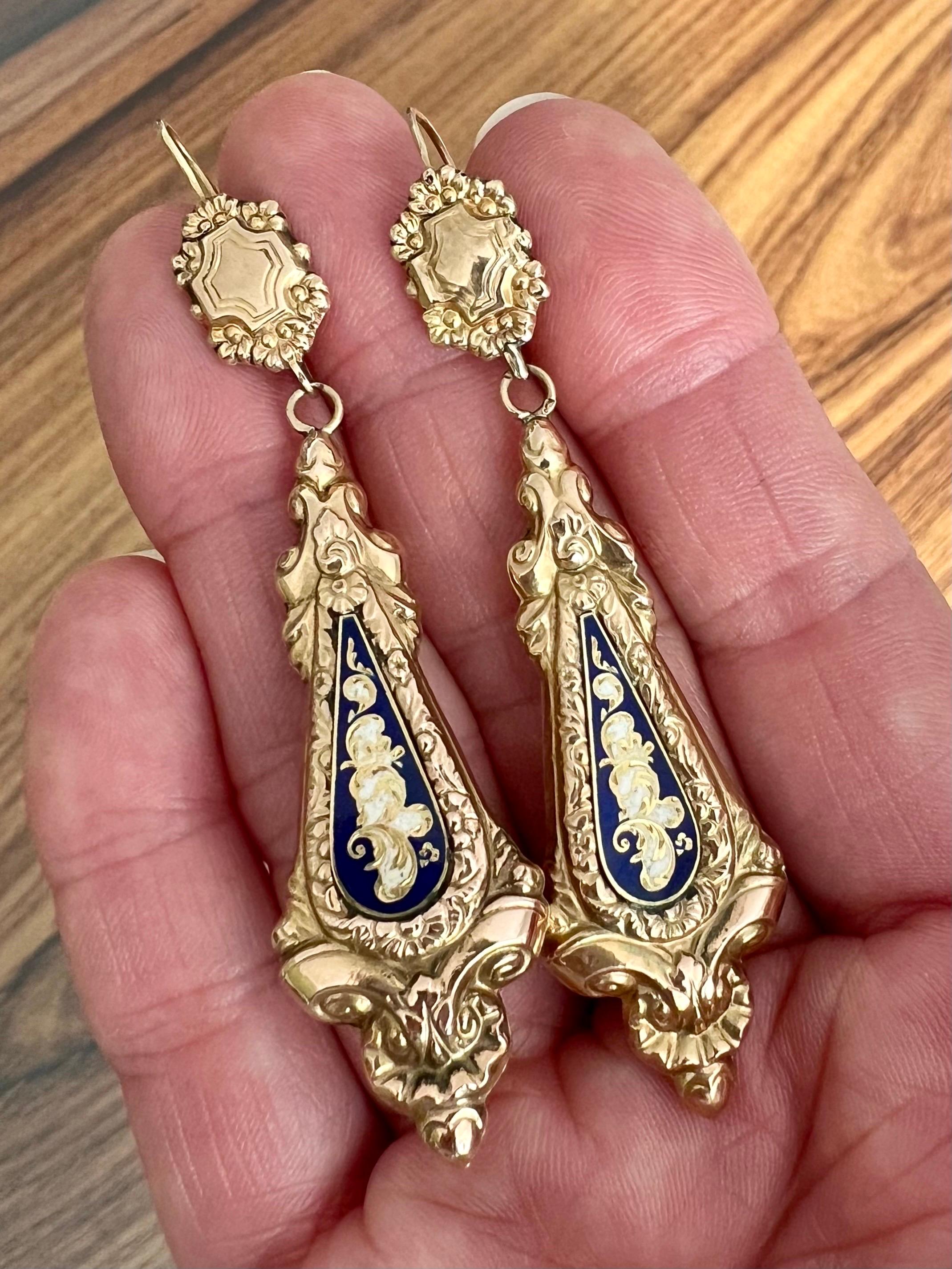 These antique Georgian 14 karat gold repoussé enameled blue and white dangle earrings are from around 1830. They are very rare. Popular motifs in this artisan era includes, flowers, crescents, ribbons, bows, leaves, feather plumes, and sprays of