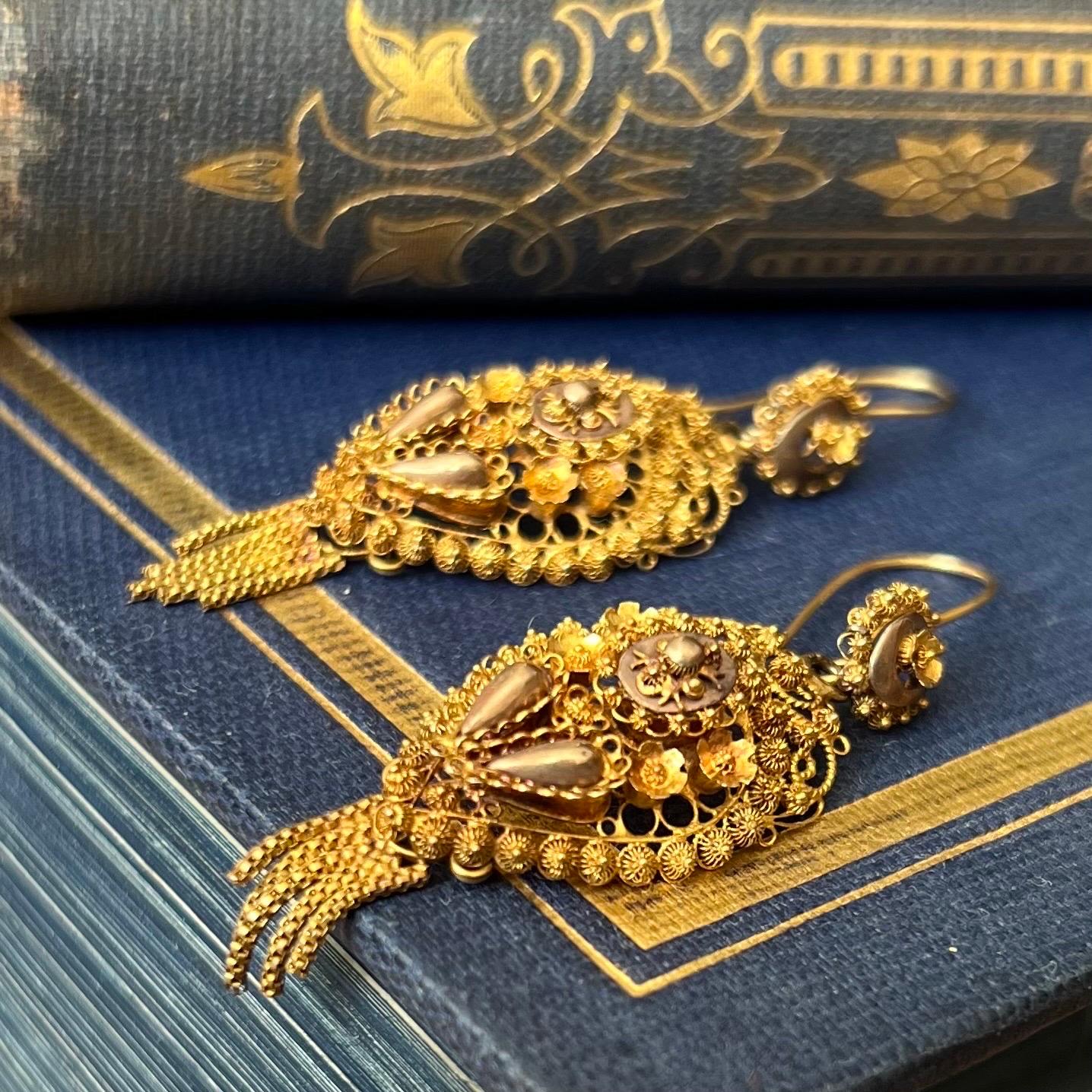 These antique 19th century filigree dangle earrings are made of 14 karat yellow gold. The earrings are beautifully crafted of twisted gold wirework and skillfully handcrafted into this lacy structure. The gold has and open foliage design made of