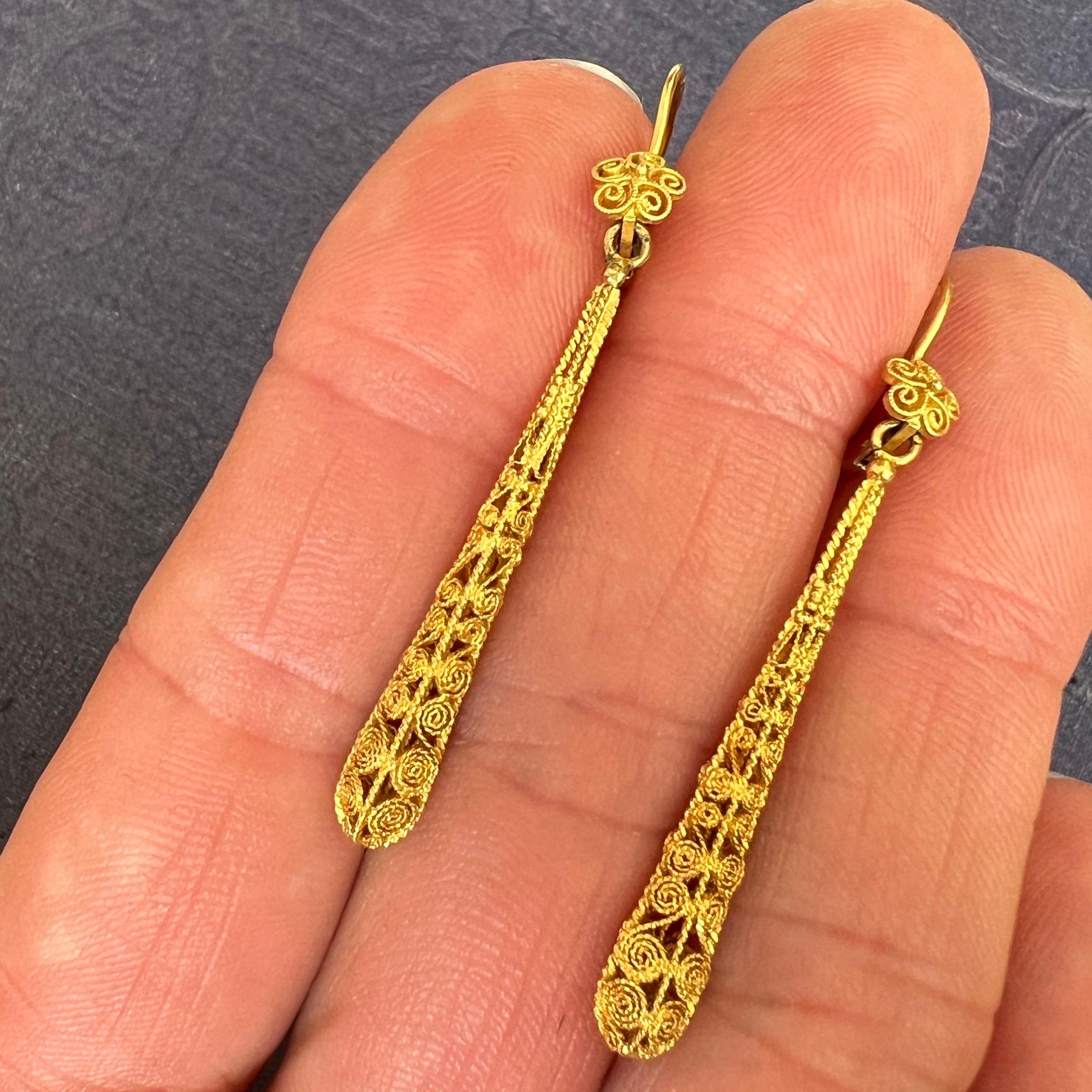These Early 20th century 14 karat yellow gold dangle earrings are beautifully made of fine filigree. The filigree is delicately made of thin gold tread - woven and twisted to form this incredible texture and detailed earrings. On top - the earpiece