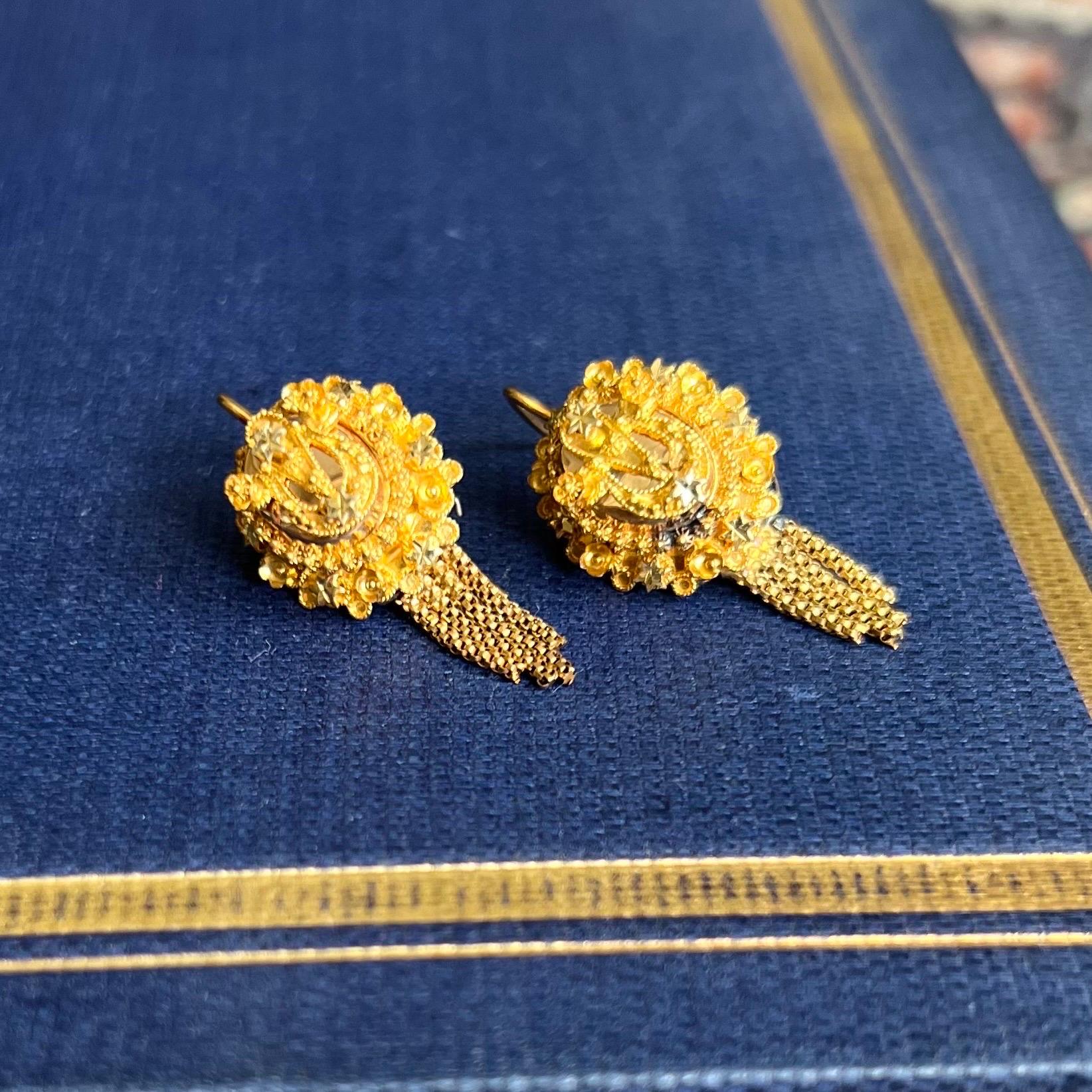 These antique 14 karat yellow gold drop earrings are created with fine cannetille work and dangling tassels. The earrings are very well made by hand with cannetille. Each earring has four tassels below the top, which characterizes these beautiful