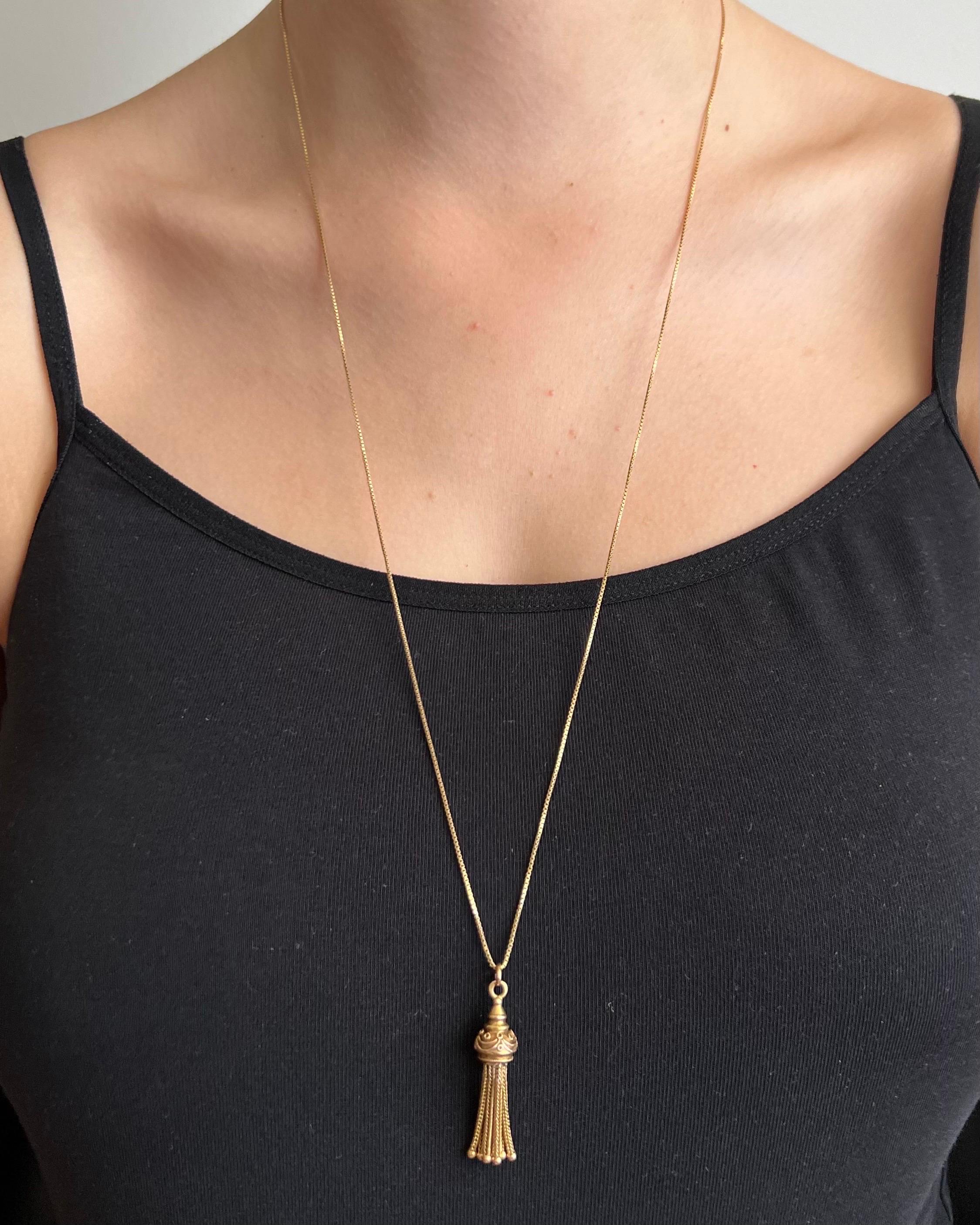 An antique box chain necklace set with a tassel pendant. The box chain necklace is made of 18 karat and the lovely tassel adorned with rope decor is made of 14 karat gold. The box chain is also called 