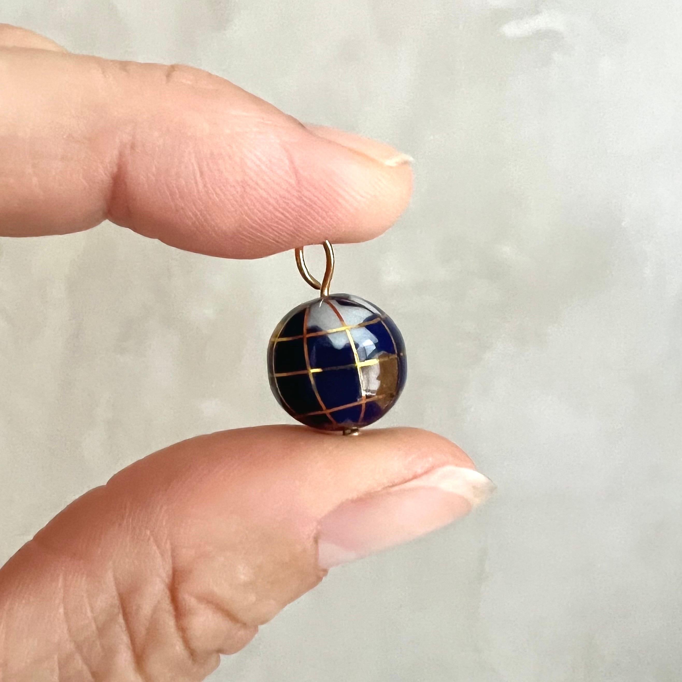 Questo squisito ciondolo a forma di piccolo globo d'oro è un gioiello straordinario che cattura la bellezza del nostro pianeta in un design vibrante e artistico. Il ciondolo presenta una rappresentazione della Terra ricca di dettagli, con i