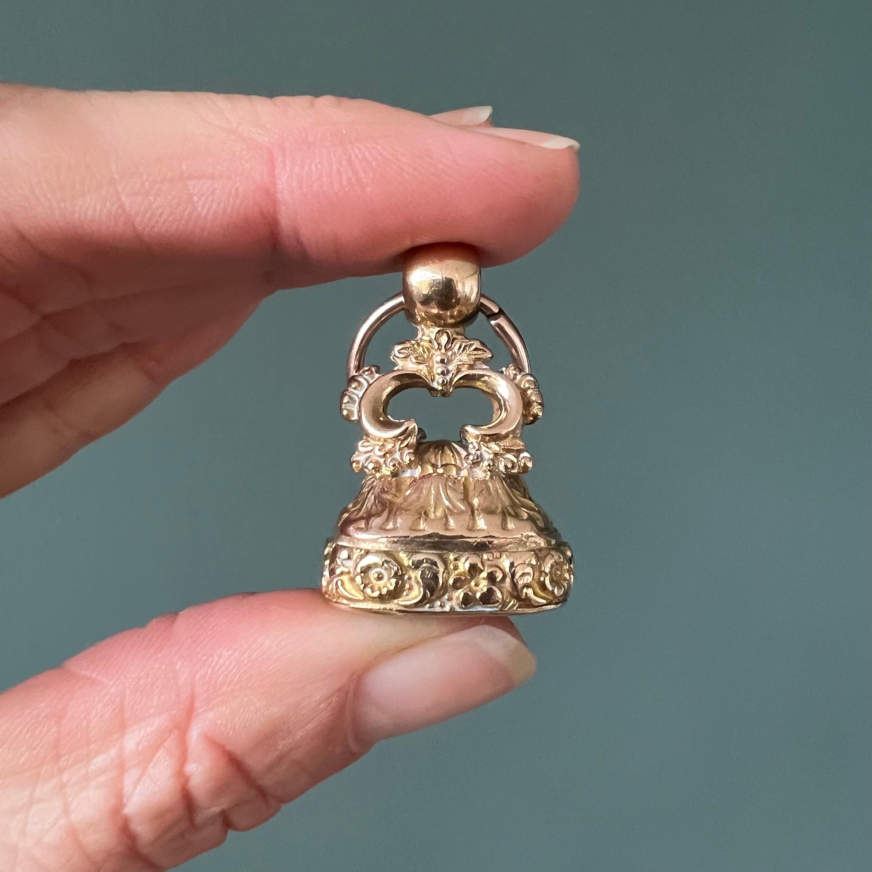 Questo squisito ciondolo a forma di fob antico georgiano è uno splendido esempio dell'ornato artigianato di quell'epoca. Il ciondolo è rivestito d'oro con intricati motivi floreali che ne decorano la superficie, mettendo in mostra l'abile