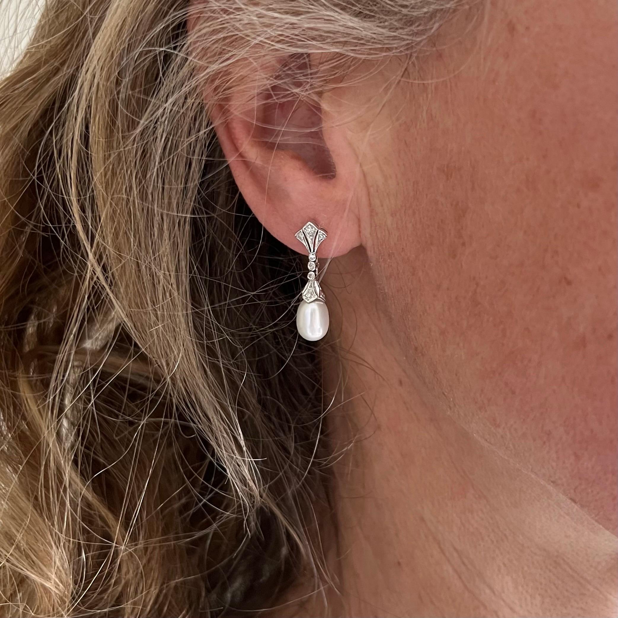 These lovely Art Deco 14 karat white gold earrings are set with a drop-shaped pearl. The upper part of the earrings are shaped into a fan, set with brilliant cut diamonds and mille griffe white gold. The mid-section consists of three movable links,