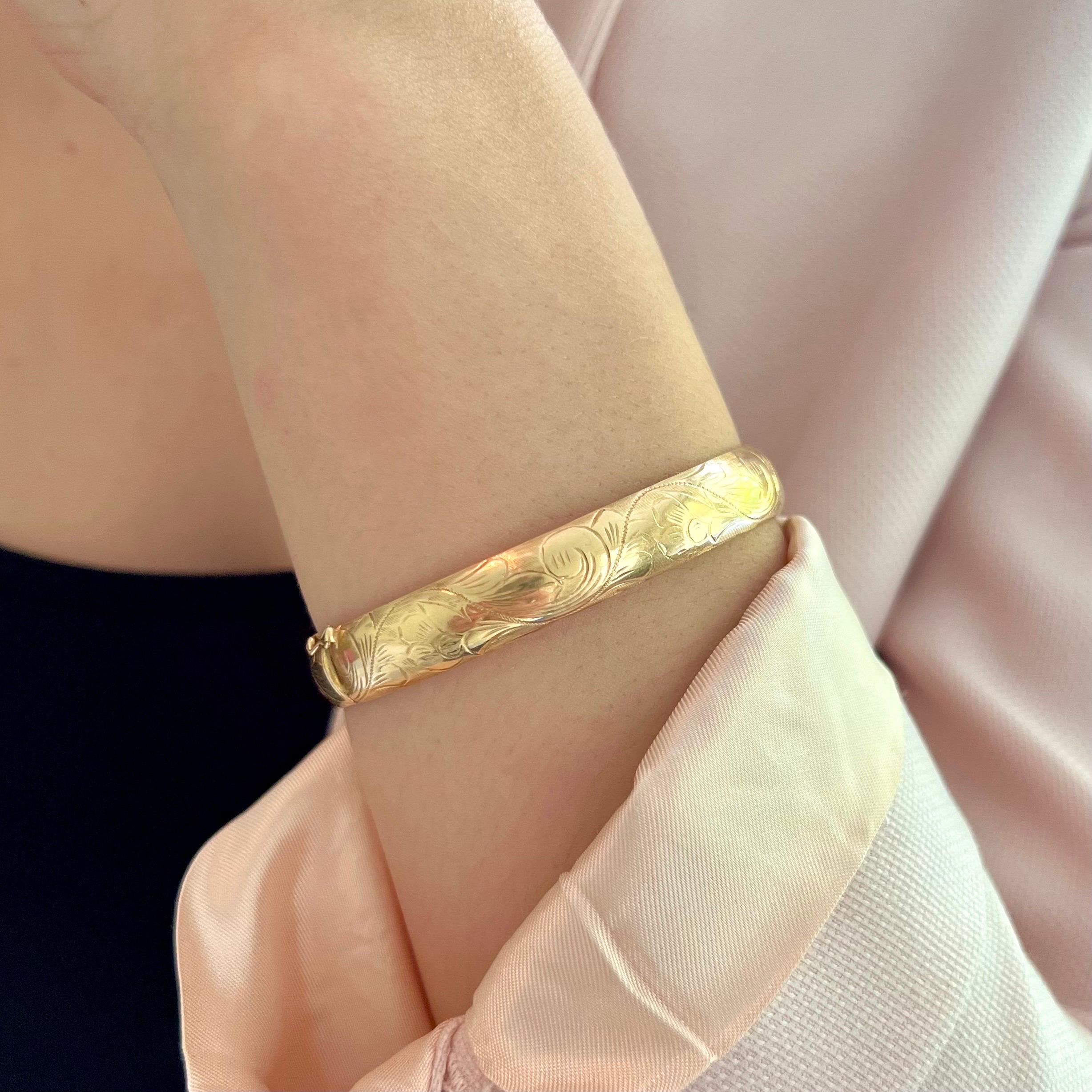 Dieses Armband aus 14-karätigem Gold im Vintage-Stil ist ein zeitloses und elegantes Schmuckstück mit einem aufwendigen, eingravierten Blumendesign, das sich wunderschön um das gesamte Armband wickelt. Die detaillierten floralen Gravuren sind fein
