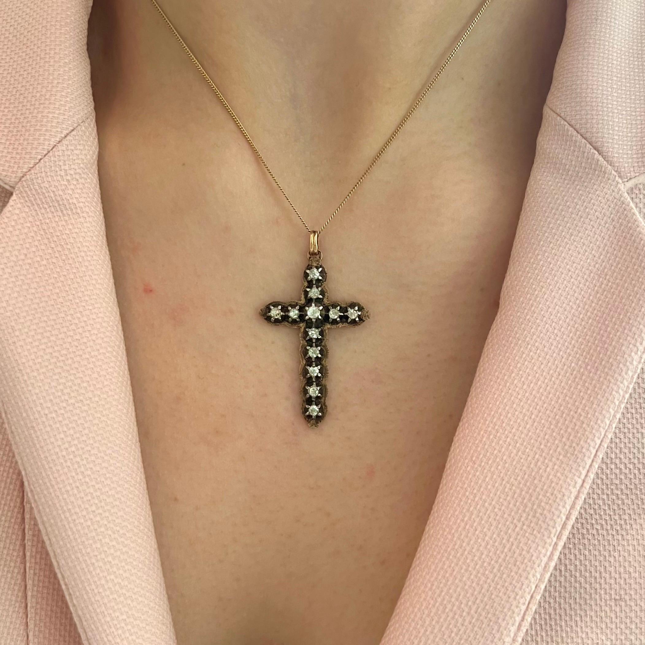 This elegant antique cross pendant is a refined example of mid-19th century devotional jewelry, dating to around circa 1850, and crafted in silver with a 14 karat yellow gold backing. The front of the cross is delicately set with a total of 12