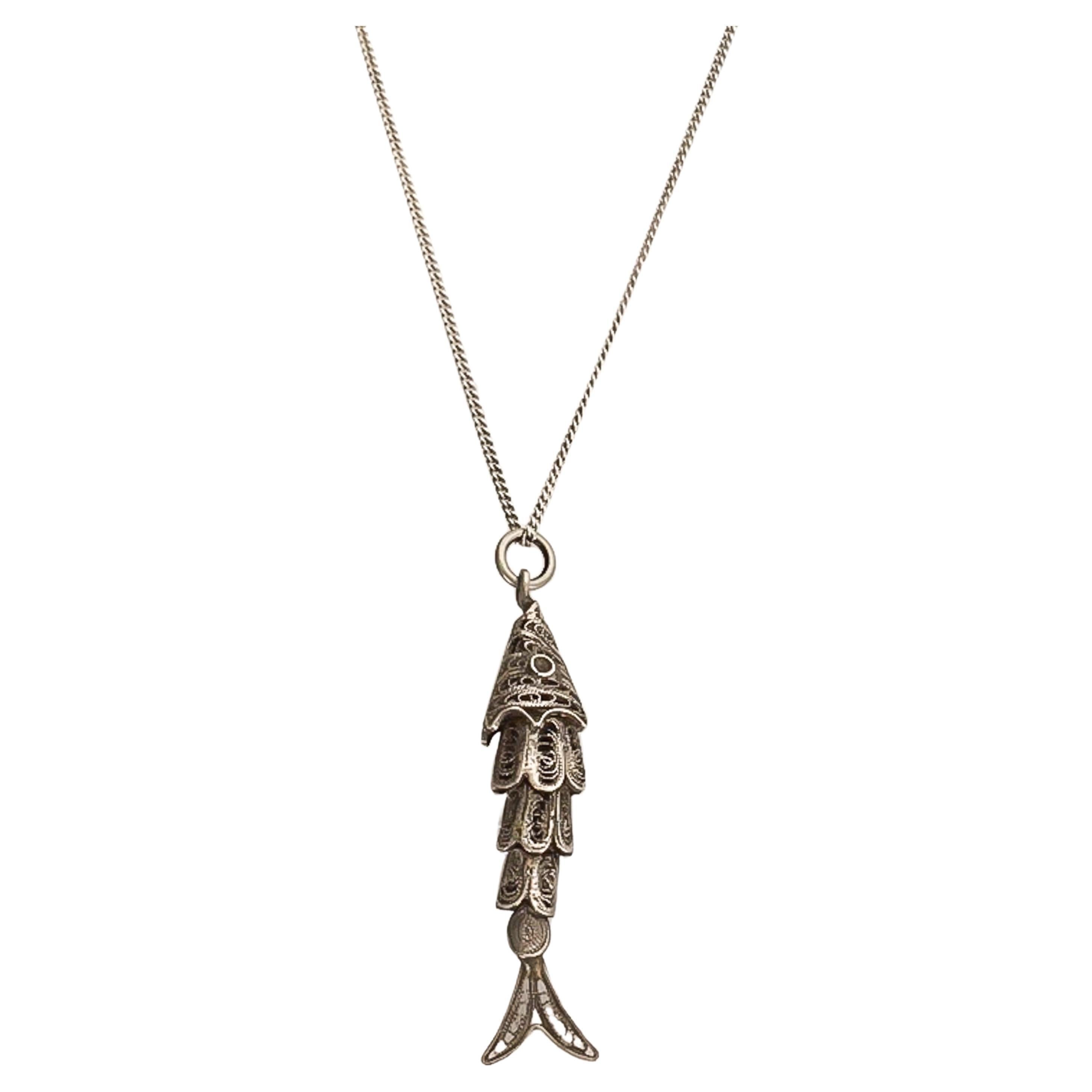 A vintage silver articulated fish charm made of four movable segments, which are finely handcrafted with filigree. It's a lovely charm to add to your charm bracelet, wear as a necklace or stacked with your other favorite pieces. The charm comes