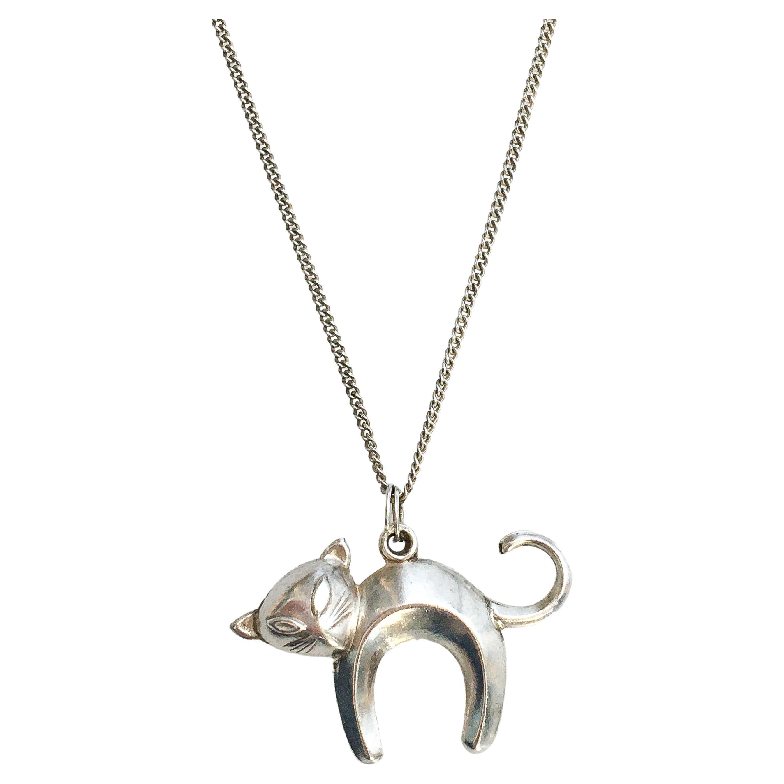 This vintage three-dimensional abstract silver arched cat charm is crafted in 835 silver. The cat is beautifully detailed and features a light brushed silver finish. Nice detailing to her ears, curled tail and arched back. The kitty cat is great