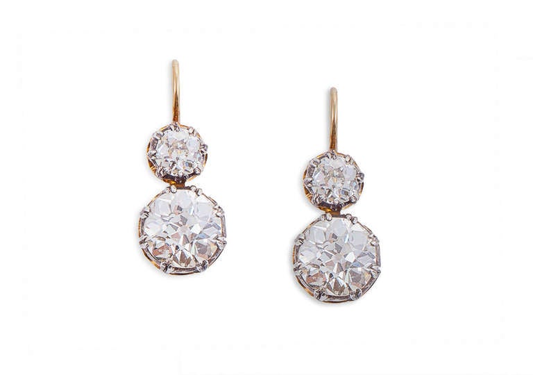 Diamonds circa 1920 in contemporary mountings. Each earring is backed in 18 karat gold, topped in silver and centers 1 larger old European-cut diamond in a split 8 prong mounting suspended from 1 smaller old European-cut diamond in a split 7 prong