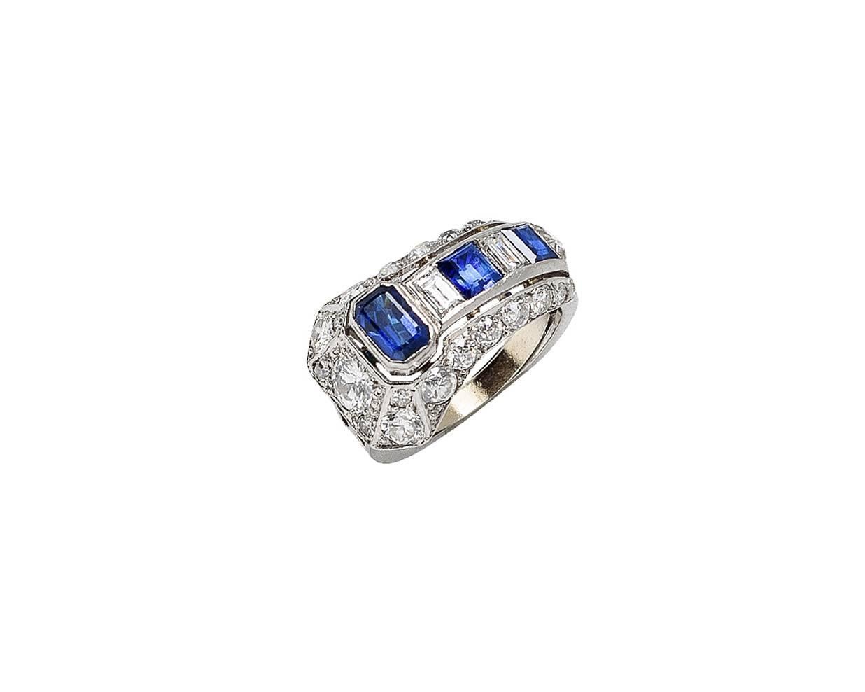 Unique Art Deco diamond and sapphire ring, the center in the shape of an arrow with a triangular-shaped diamond at the point and a bezel-set sapphire in the rear. The shank is intricately pierced and currently contains a platinum ring guard for