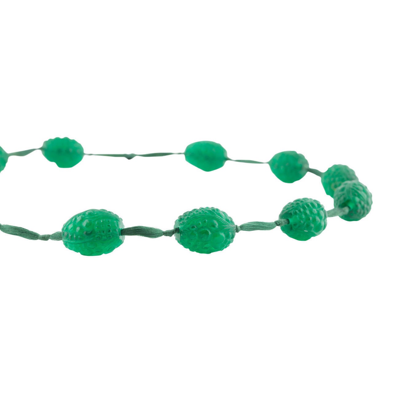 Lalique, René (1860-1945)
Grosses Graines Necklace  1920
12 Emerald green Lalique beads in the shape of  large grains, threaded on matching silk cord. Featured in Lalique catalogues from 1928 and 1932, not produced after