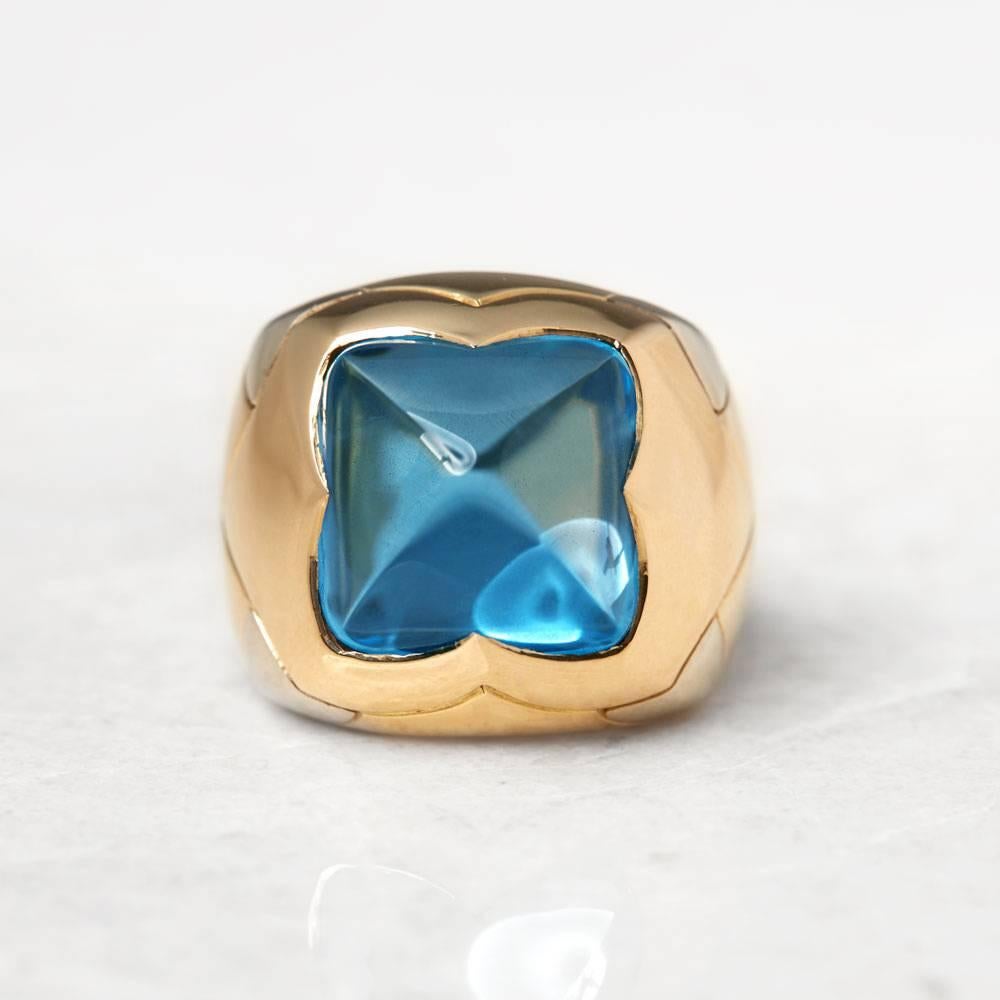Ref:	COM1014
Size: L.5, Band Width - 4mm
Box & Papers: Bulgari Box
Material: 18k Yellow & White Gold, total weight - 16.26 grams
Gemset: Set with one cabochon sugarloaf cut blue Topaz
Condition - 9 - Excellent Condition

This Ring by Bulgari