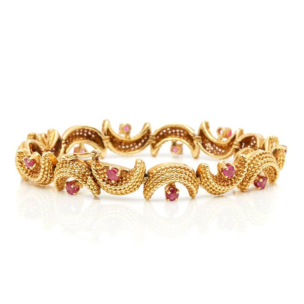 Ref:	COM1413
Serial Number: 748*
Age: 1950's
Size:	 Bracelet Length - 17.5cm, Bracelet Width - 9mm
Box & Papers:	Xupes Presentation Box
Material: Yellow Gold
Gemset: Set with 14 round cut Rubies of approximately 1.00ct total
Condition: 8 - Good