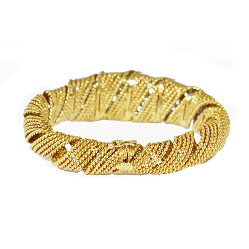 An 18ct yellow gold tapered cylindrical bangle, with five pavé diamond sections.
Bracelet measures 22cms (9.4") x 2.3cms (0.8")