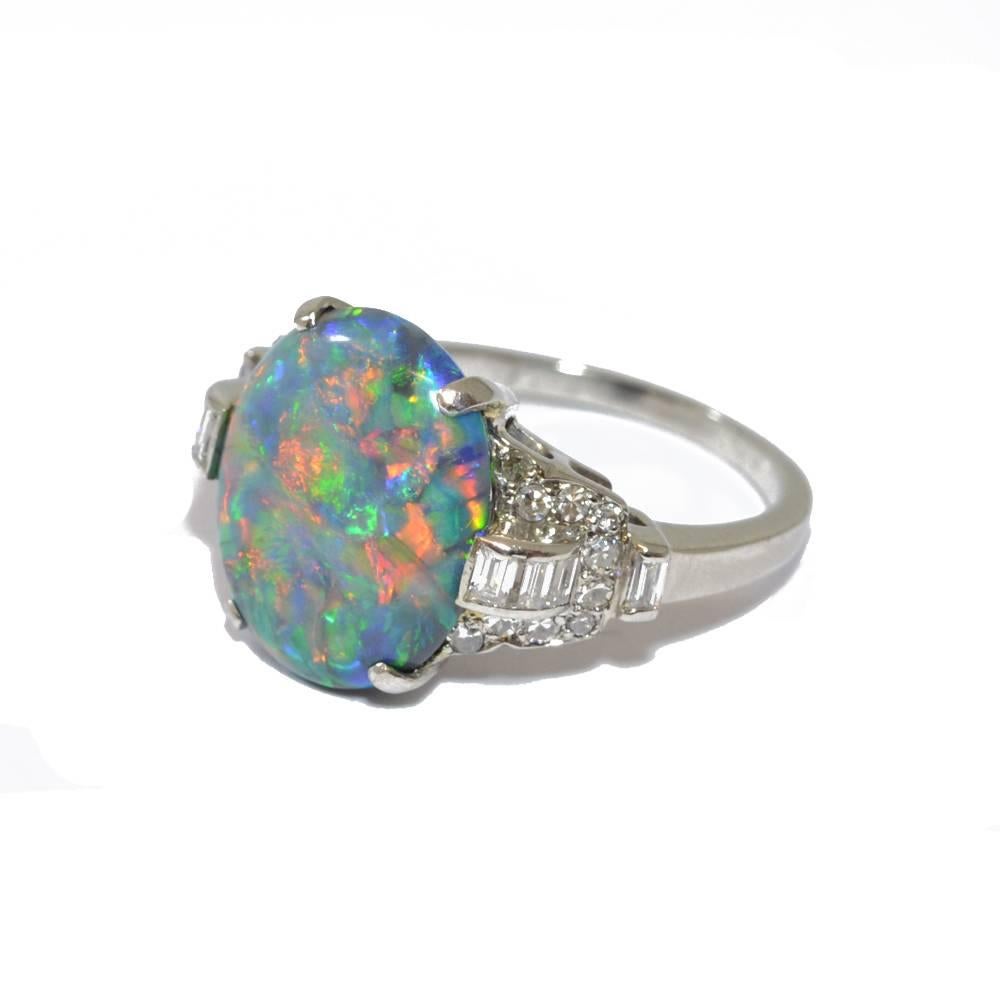 An Deco ring set with a fine oval black opal and diamond set mount. Mounted in platinum. American, circa 1920.
Ring size L 1/2