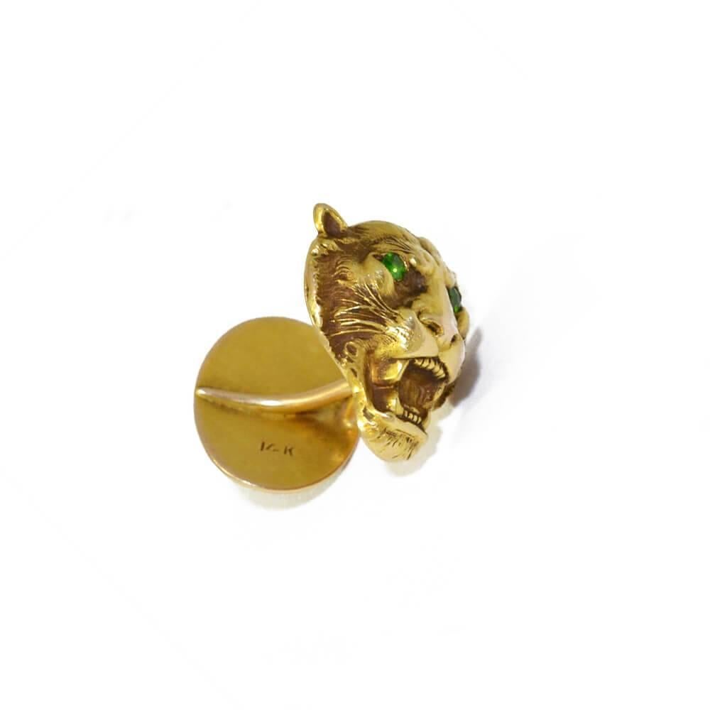 A pair of 14ct yellow gold cufflinks in the form of roaring lion heads, with demantoid garnet set eyes. having curved bar fittings, the reverse panel depicts lion claws with a cartouche for engraving initials. American, circa 1890.