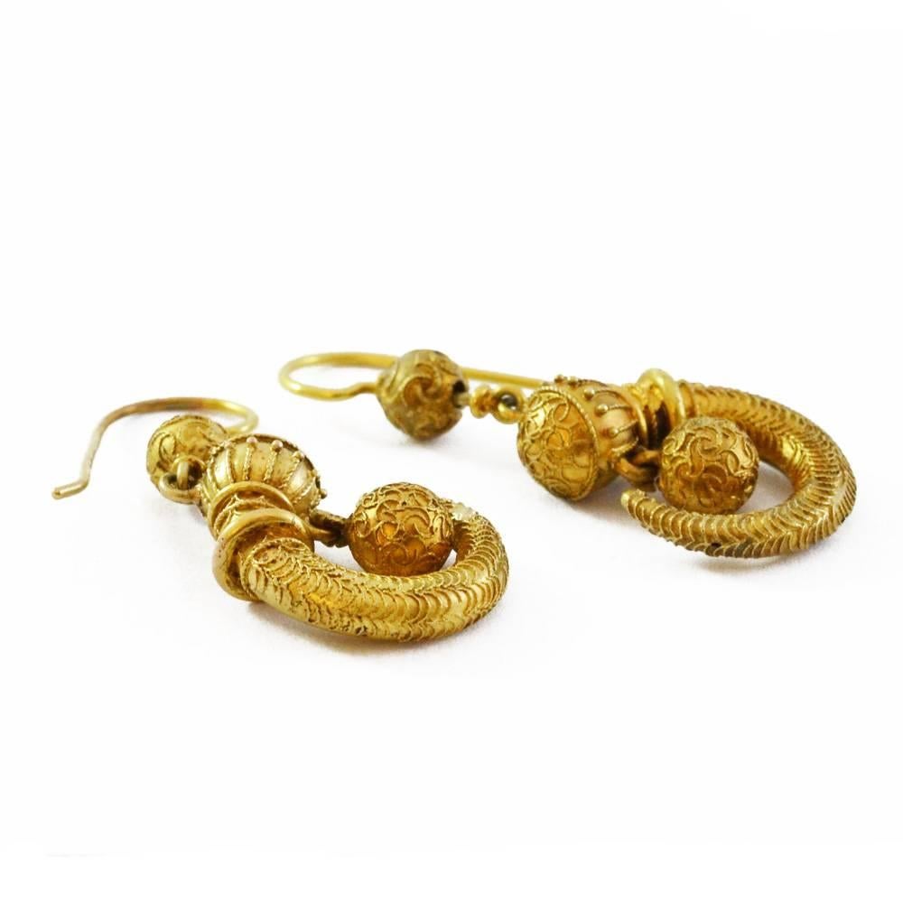 A pair of gold Archeological Revival earrings in the form of golden cornucopias with granulated detailing. English circa 1860.