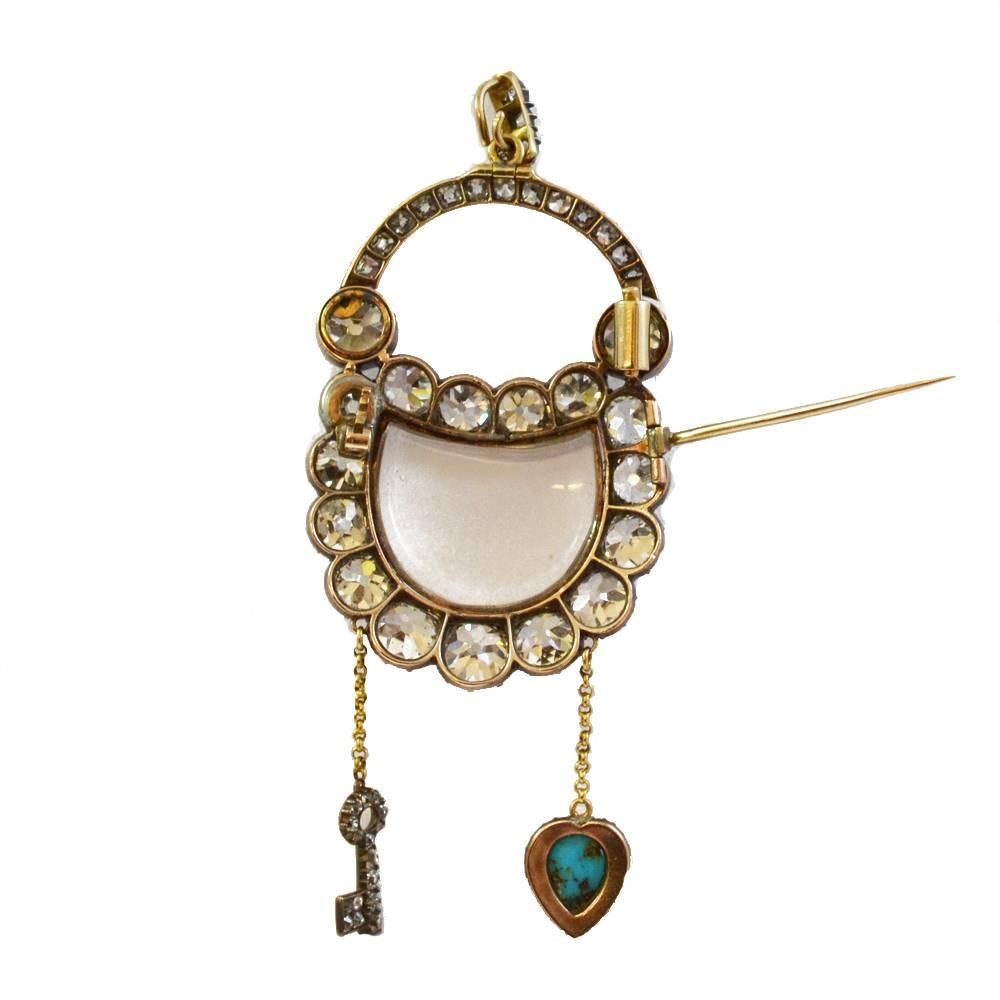 A Georgian padlock brooch/pendant. The central crystal section surrounded by old cut diamonds, with a diamond set opening arm. A turquoise and diamond set heart, and a diamond set key suspend from the padlock symbolising ‘the key to your heart’.