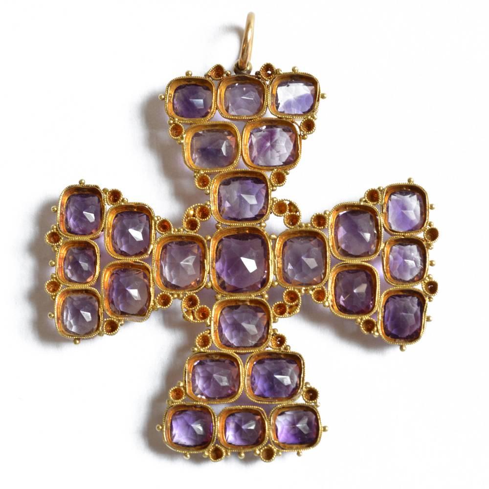 A Georgian amethyst pendant in the form of a Maltese cross. Each cushion shaped amethyst is bezel set and intricately joined with cannetille work. 18ct yellow gold. English circa 1840.