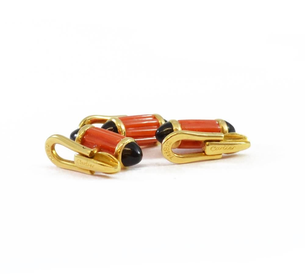 A dress set consisting of a pair of cufflinks and three buttons, of fluted coral cylinders with cabochon onyx terminals, all set in 18ct yellow gold. By Cartier, numbered 741815.  London, circa 1970.