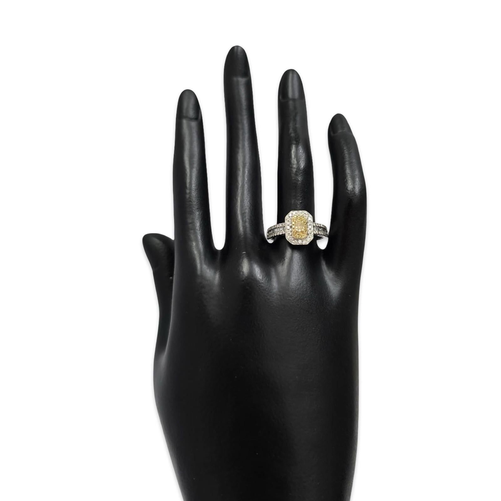 Cette bague contemporaine sophistiquée présente un diamant jaune vif au centre, encadré d'un double halo de diamants blancs ronds et brillants. Fabriquée en or blanc 18 carats et pesant 3,3 grammes, la bague présente un poids total de diamants de