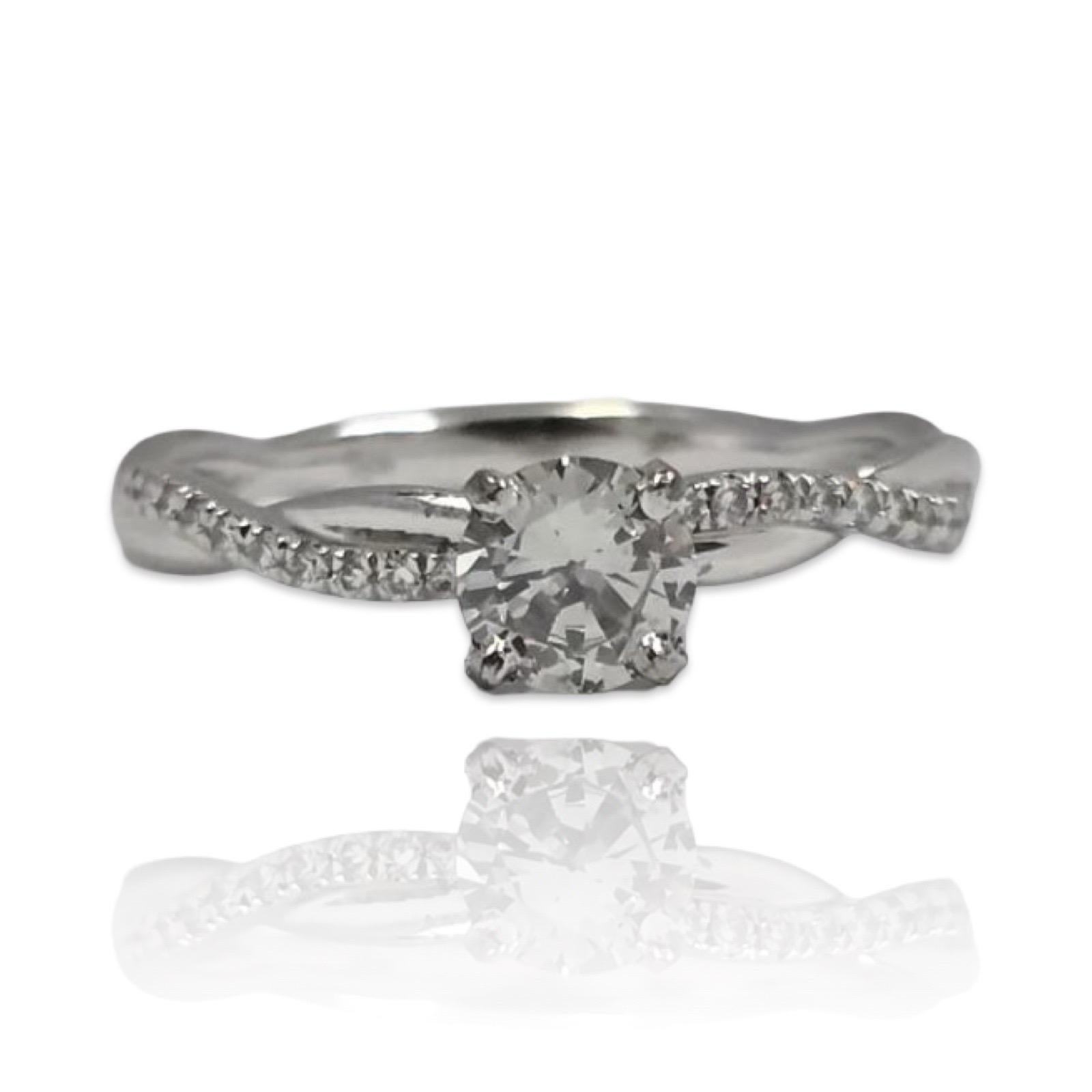 Cette élégante bague, qui constitue une variante captivante du solitaire classique, est ornée d'un rare diamant naturel de couleur gris pâle certifié par la GIA et pesant 0,43 carat. Le centre, de forme ronde et taillé en brillant, présente une