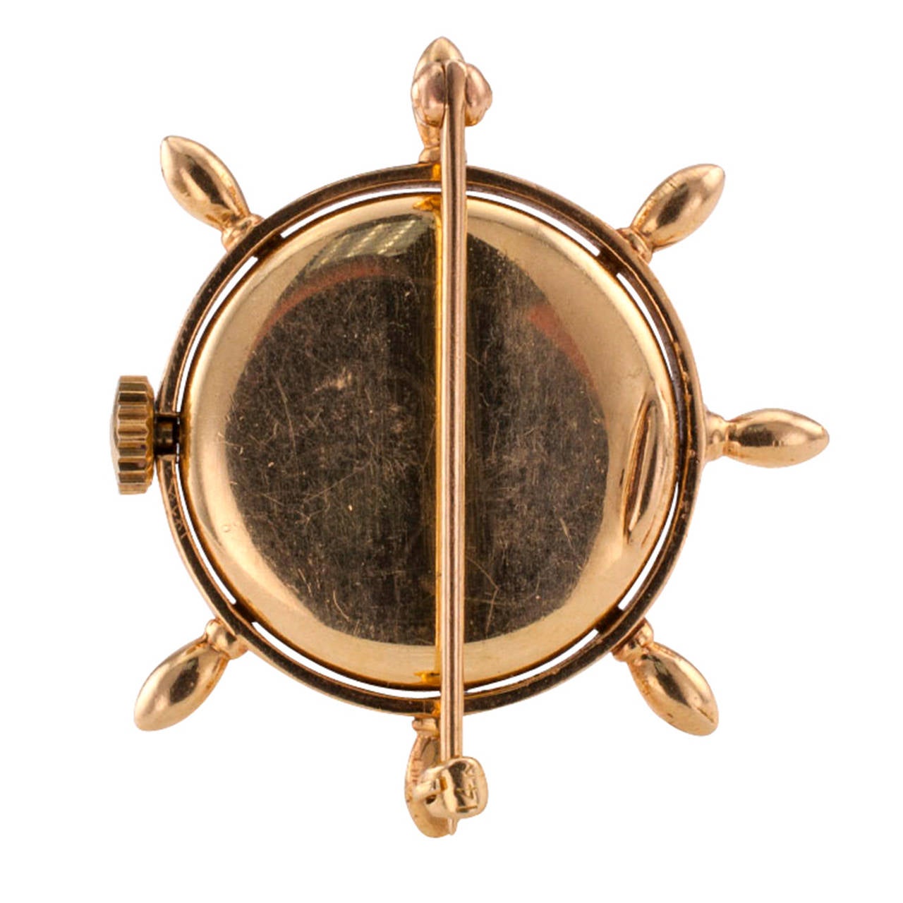 Circa 1950, a most uncommon brooch design, incorporating a circular dial watch, the white dial with Arabic numbers, signed Tiffany & Co. within a frame designed as a ship's wheel, the 17-jewel Swiss movement signed Movado, mounted in 14 karat gold,