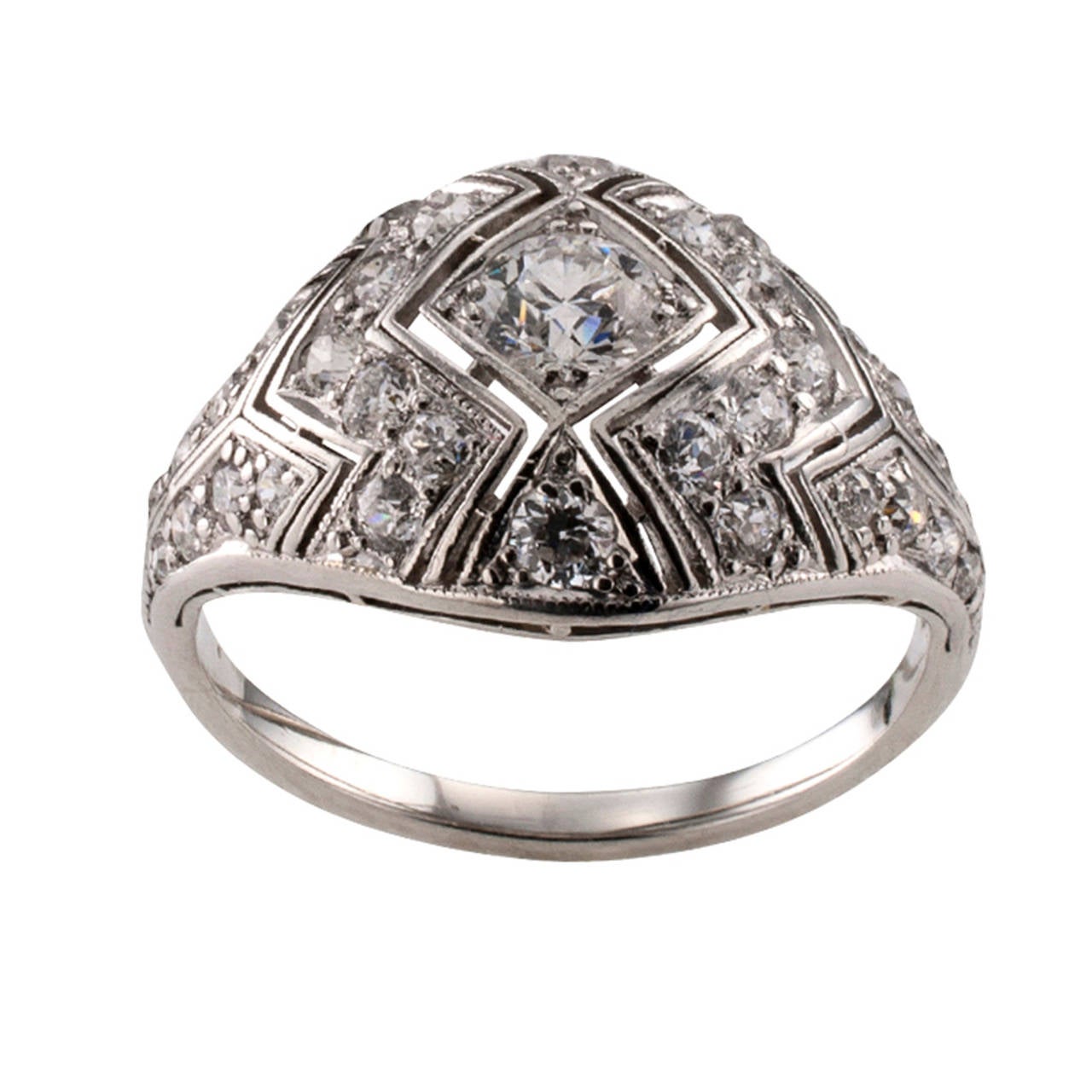 Circa 1925, this beautiful Art Deco ring with its slightly domed design is  decorated with open work and geometric motifs and set throughout with thirty-three old-cut round diamonds varying in size and totaling approximately 1.25 carats,