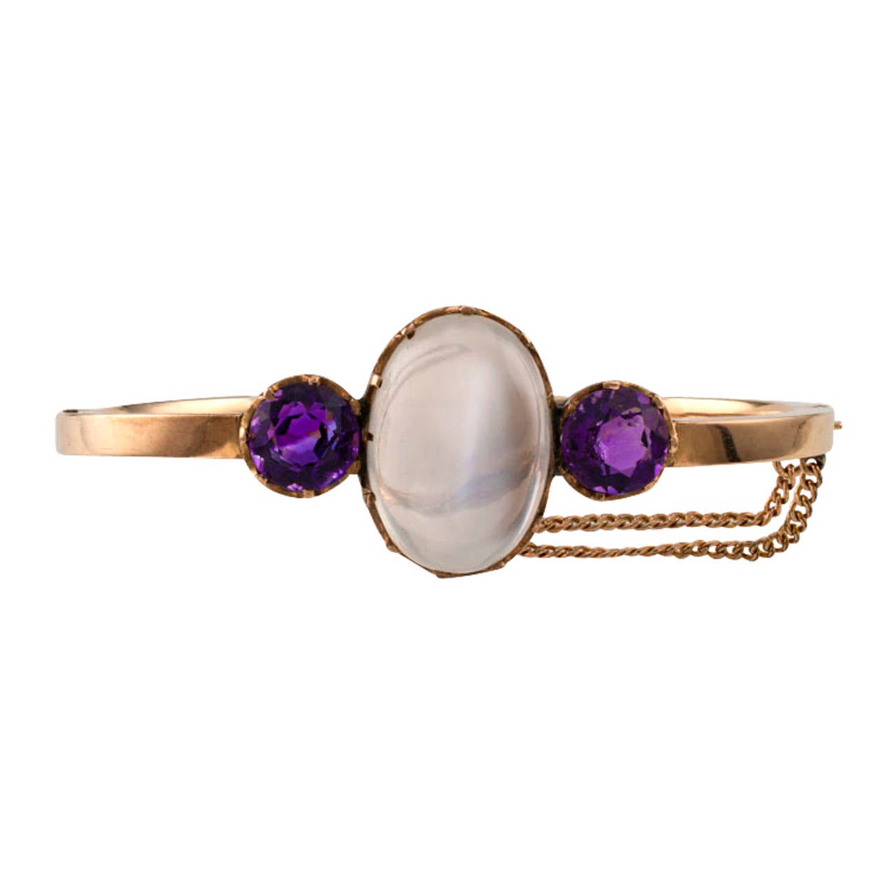 This unique Victorian moonstone and amethyst bangle was made around 1900.  The hinged design centers upon a mystifying color scheme dominated by a beautiful glowing, oblong moonstone, artfully set between a pair of bright faceted round amethysts,