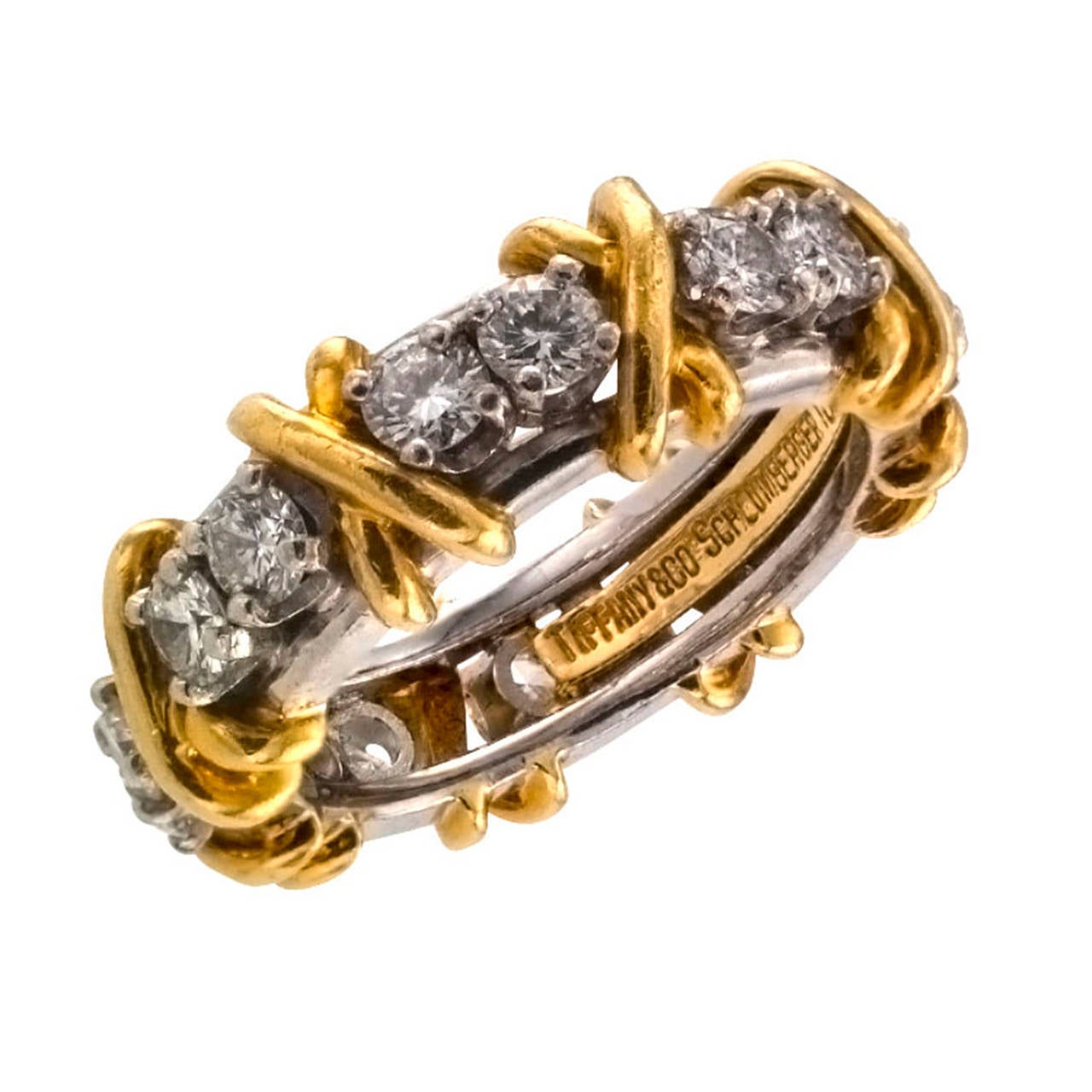 Tiffany & Co. Schlumberger 16 Stone Eternity band

A popular and classic design by one of Tiffany & Co.'s most famous designers.  Eight pairs of diamonds, you and I repeated eight times between golden X's, the sixteen diamonds totaling
