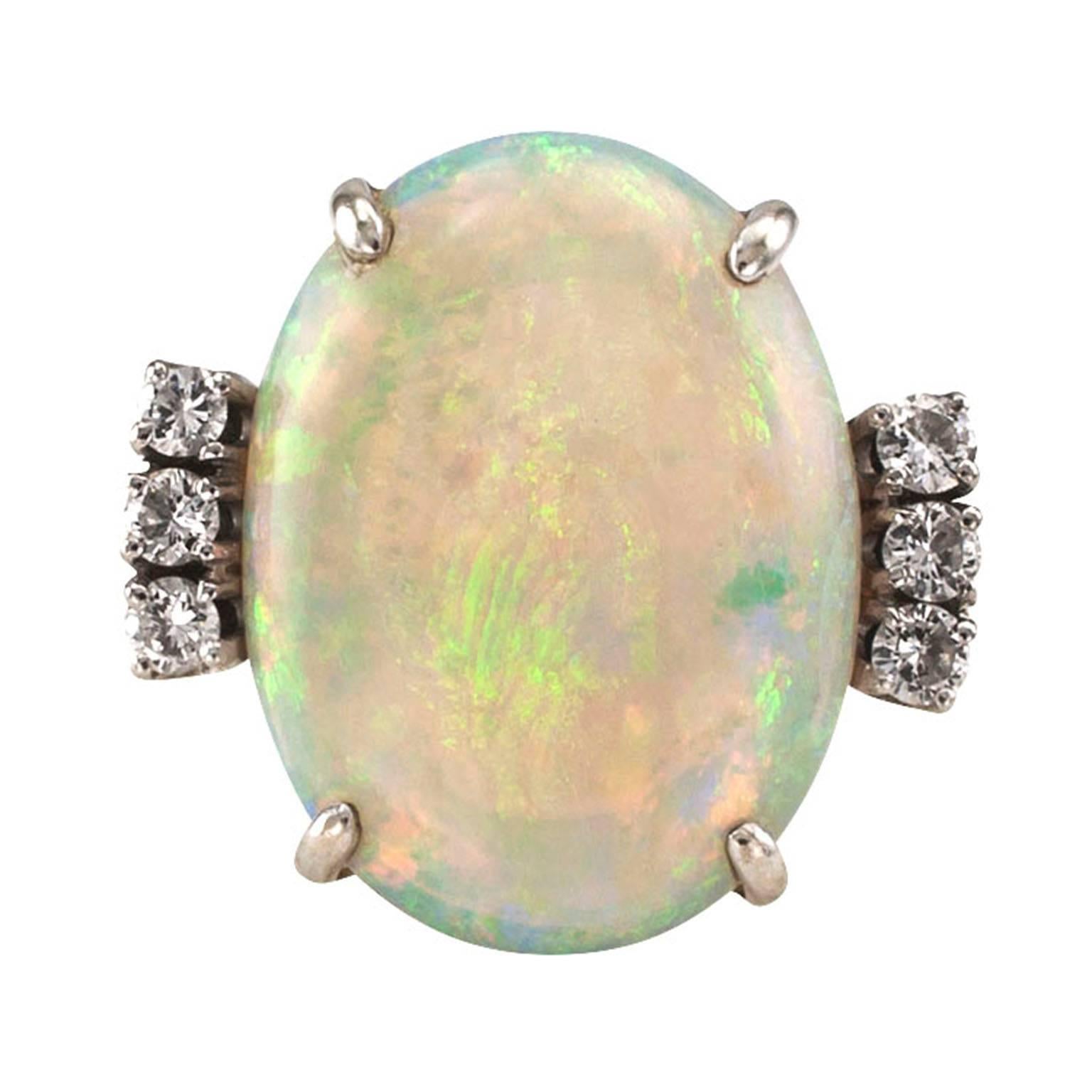  Opal and Diamond White Gold Ring

Characteristic of nice opals, softly shimmering from its 18 karat white gold mount, this one exhibits subtle shades of red, green, orange, pale blue and many other colors in between.  Flanked by six round