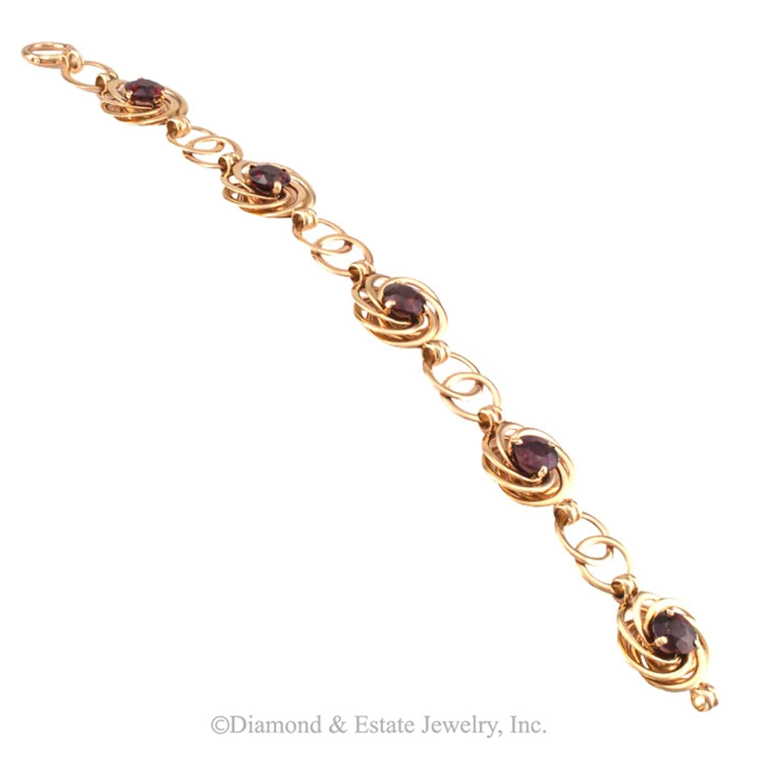 Retro Garnet and Gold Bracelet Circa 1940

It is all about circles.  Circles chasing each other and forming circular florets at even intervals.  Each floret centers upon a bright garnet... pure Retro.  In contact with skin, the linkage feels silky