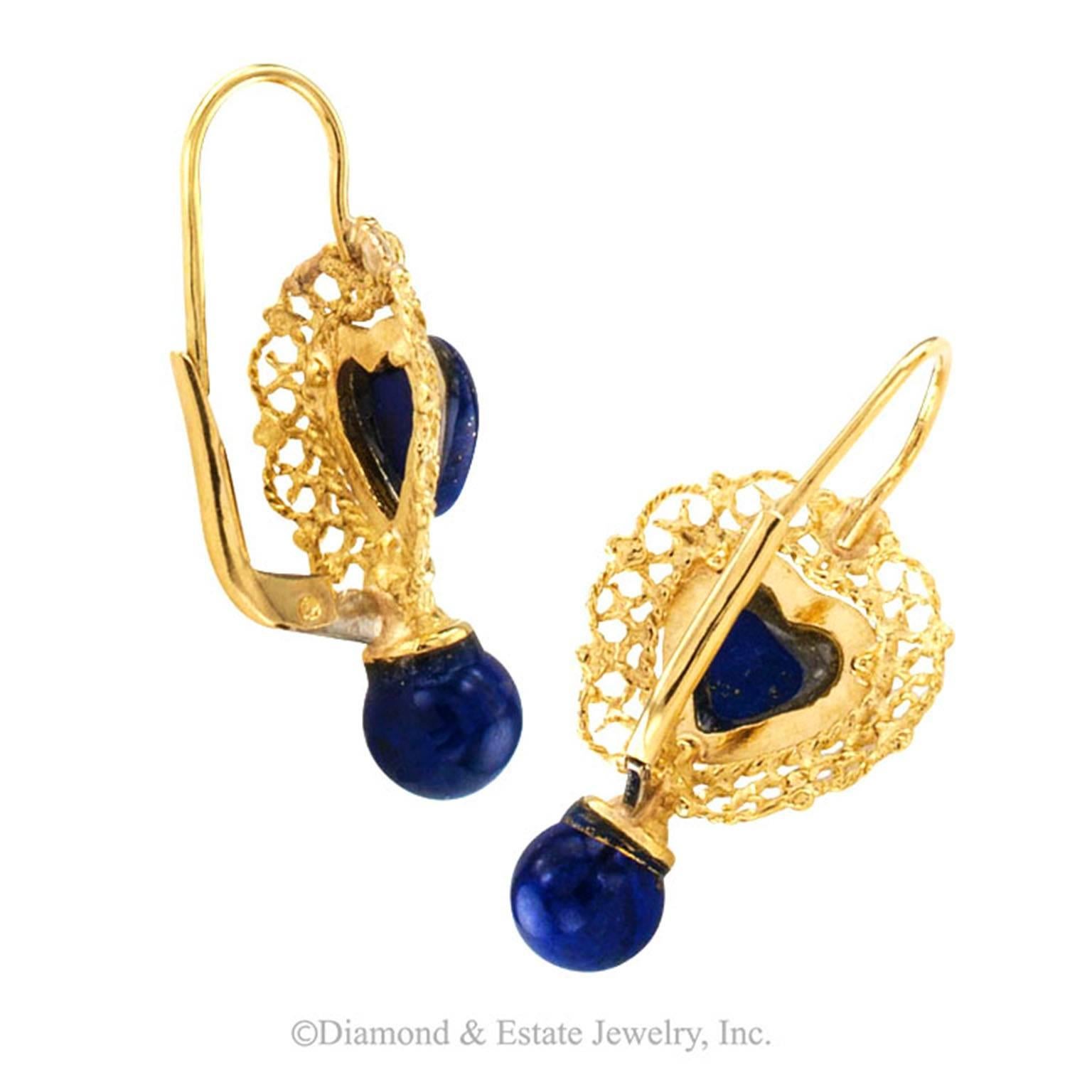 Lapis Lazuli and Gold Drop Earrings

Embracing filigree work formed by strands of corded yellow gold highlighting a pair of heart-shaped lapis lazuli cabochons with a great deal of pyrite inclusions that resemble shimmering stars in the night sky,