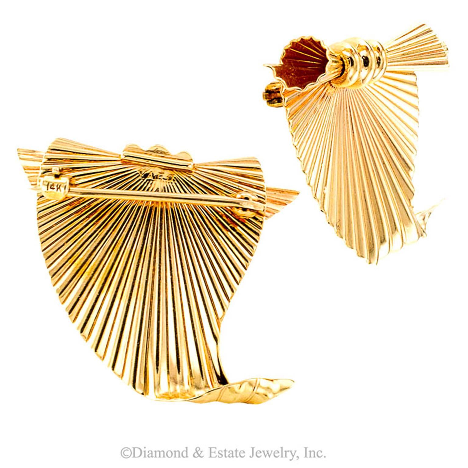 Raymond Yard Estate Retro Pair of Brooches Circa 1940

Like unfurling sails in the breeze, the hand fabricated designs feature radiating pleats of gold, ablaze with the unmistakable glow of polished gold.  There is a great deal of dimensionality, 