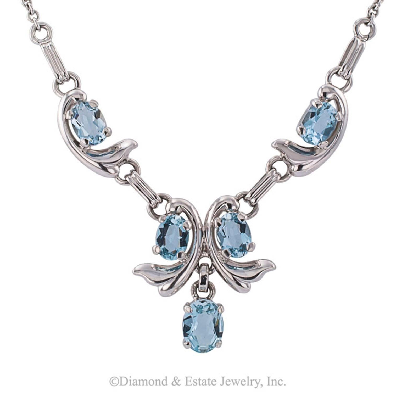 1950s Aquamarine White Gold Necklace

The front section set with five oval aquamarines totaling approximately 4.00 carats, mounted in 14-karat white gold, circa 1950.  Most definitely a wearable necklace, pretty.  If you are fond of aquamarine,