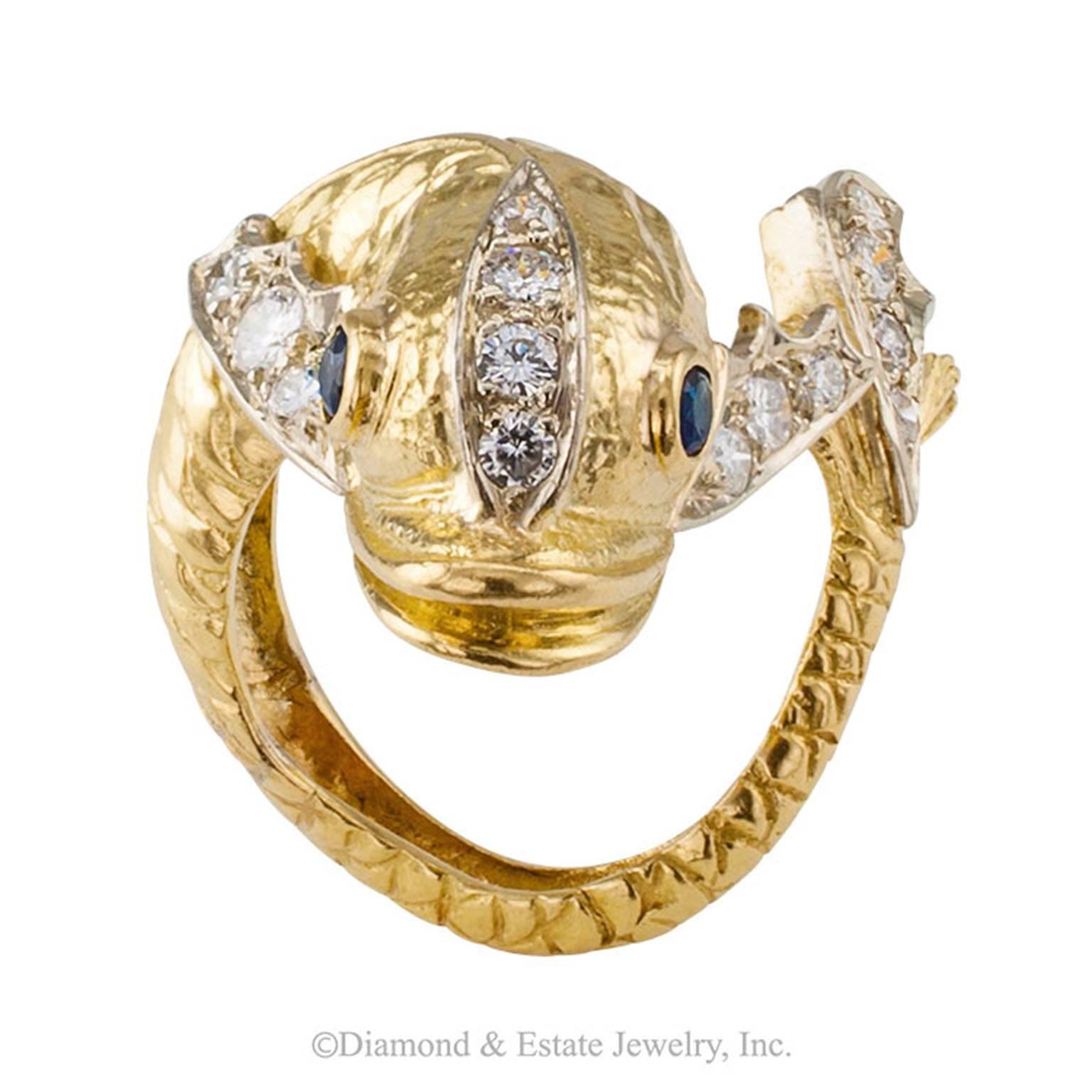 Wrap-around-the-finger Diamond and Sapphire Fish Ring

Whimsical diamond, sapphire and 18-karat gold fish ring, circa 1970.  A full body fish, its head rests on top of the finger while its body curls completely around it to reveal its diamond tail