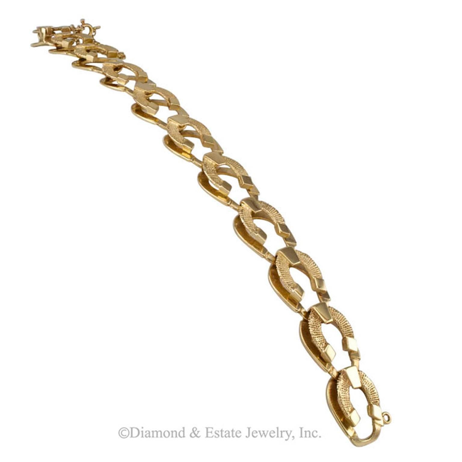 1950s Horseshoe Link Gold Bracelet

Mid-century horseshoe link 14-karat yellow gold lady's bracelet circa 1950.  The design features a textured gold horseshoe motif overlapping a similar bright polished gold motif producing an attractive and
