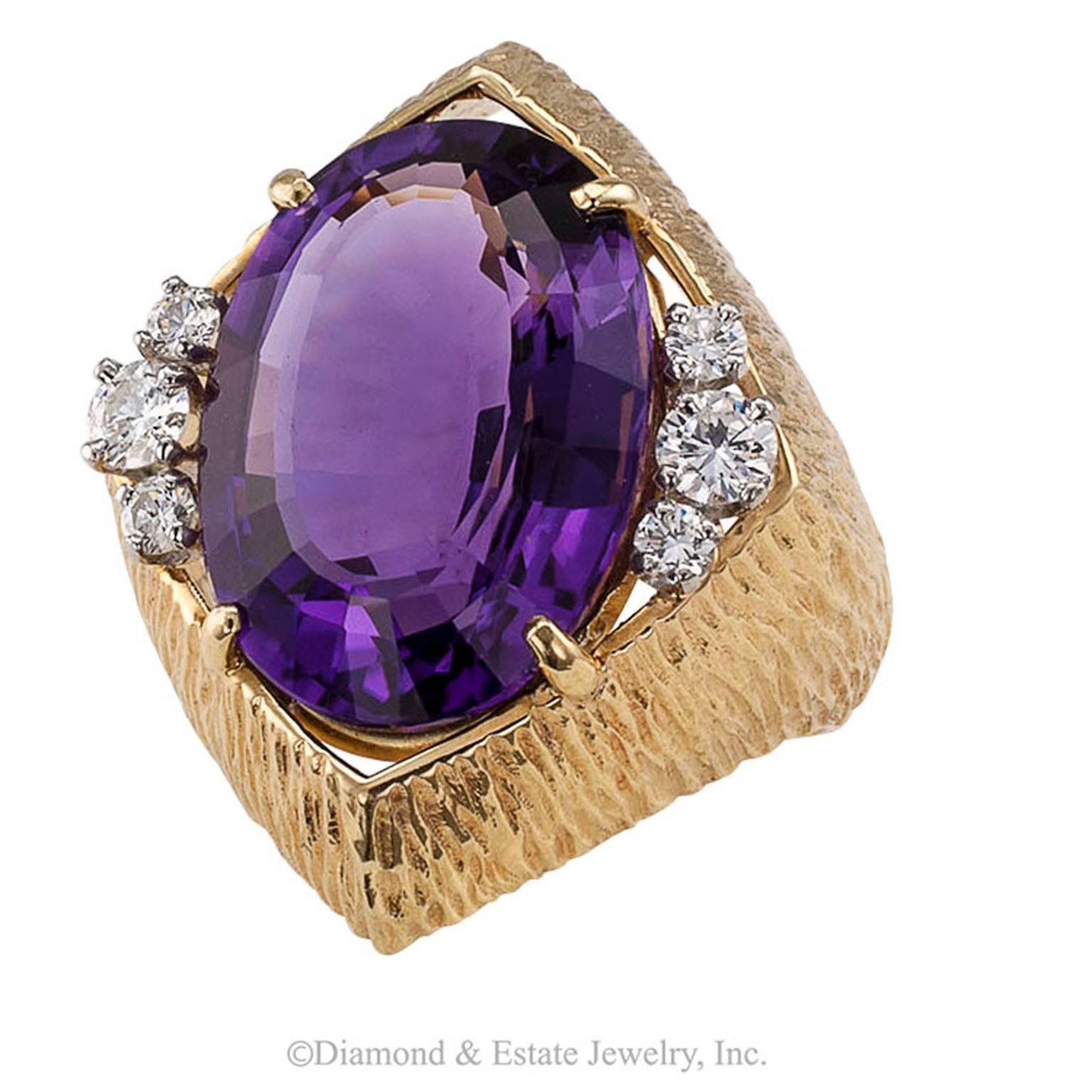 Amethyst Diamond Cocktail Ring

1970s Large oval amethyst and diamond textured gold cocktail ring.  It is one of those rings that grabs your attention and refuses to let go of it.  The bright royal purple amethyst weighing approximately 11.00