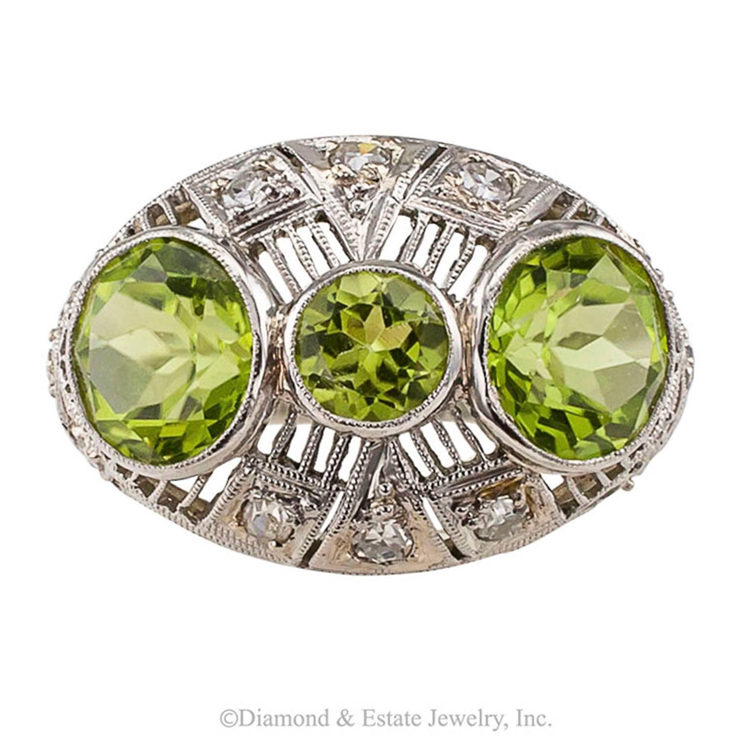 Art Deco Peridot Diamond Platinum Ring

Art Deco peridot and diamond domed platinum ring circa 1925.  Intensive filigree and millegrain decorate the slightly domed design set with three vibrant round peridot framed by a geometric arrangement of