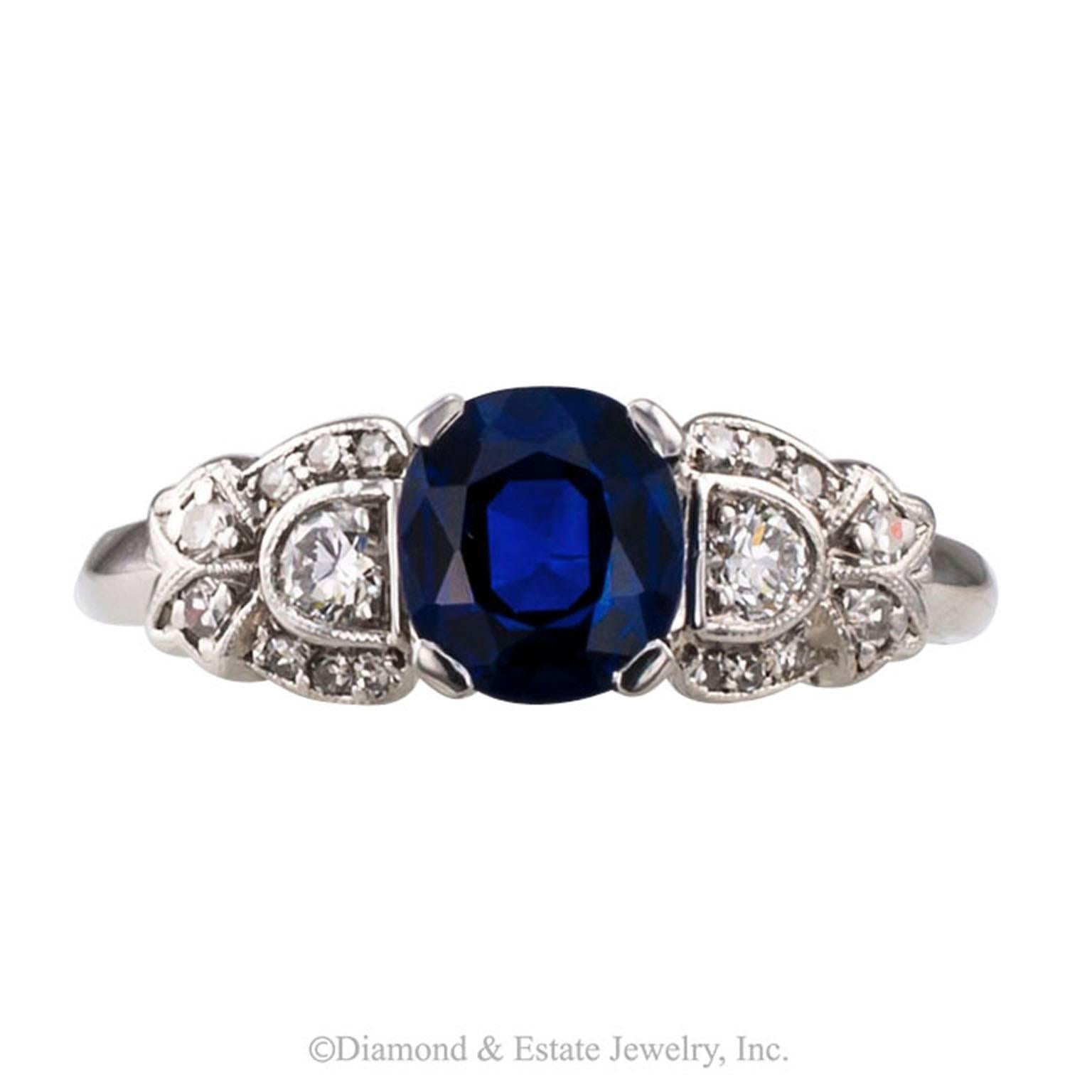 Art Deco Sapphire Diamond Platinum Ring

1930s sapphire and diamond solitaire ring mounted in platinum.  The design centers upon a very pretty cushion-shaped blue sapphire weighing 1.23 carats, between geometric shoulders set with diamonds