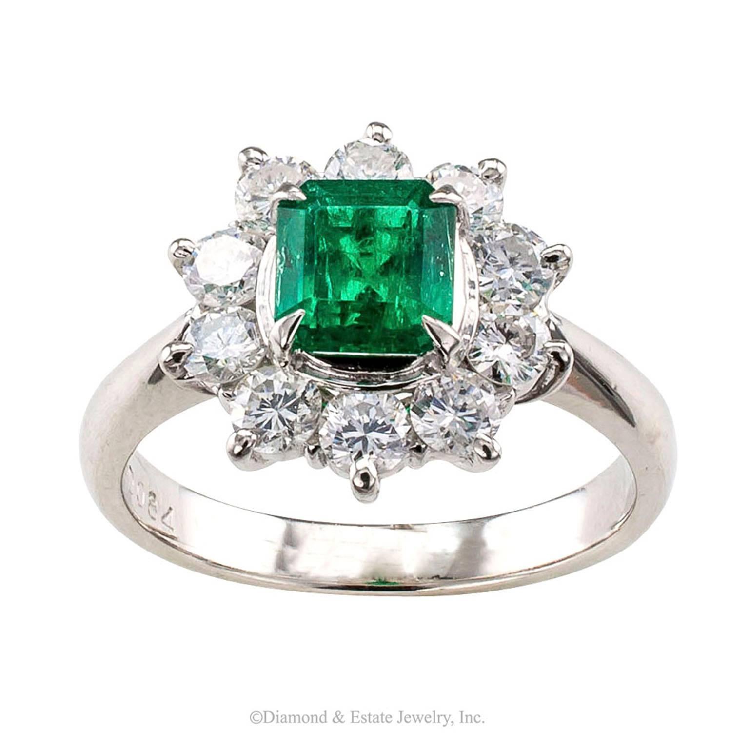 Emerald Diamond Halo Platinum Ring

Emerald and diamond halo platinum ring circa 1990.  Centering a fine emerald-cut Colombian emerald weighing 0.76 carat within a halo of round brilliant-cut diamonds totaling approximately 0.84 carat, approximately